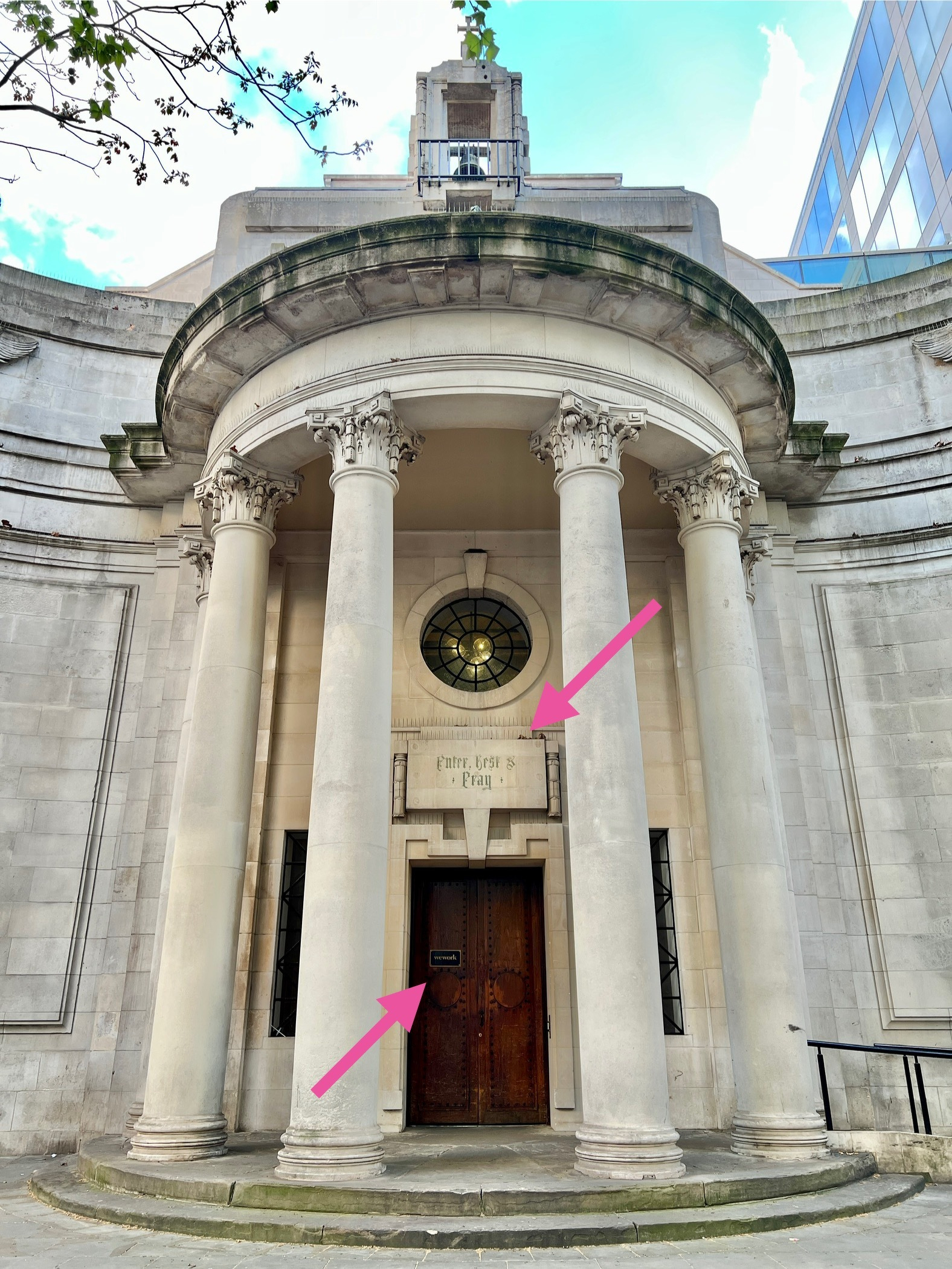A church with a gothic sign above the door “EAT, REST, & PRAY” but a small sign on the wooden door with a “wework” logo