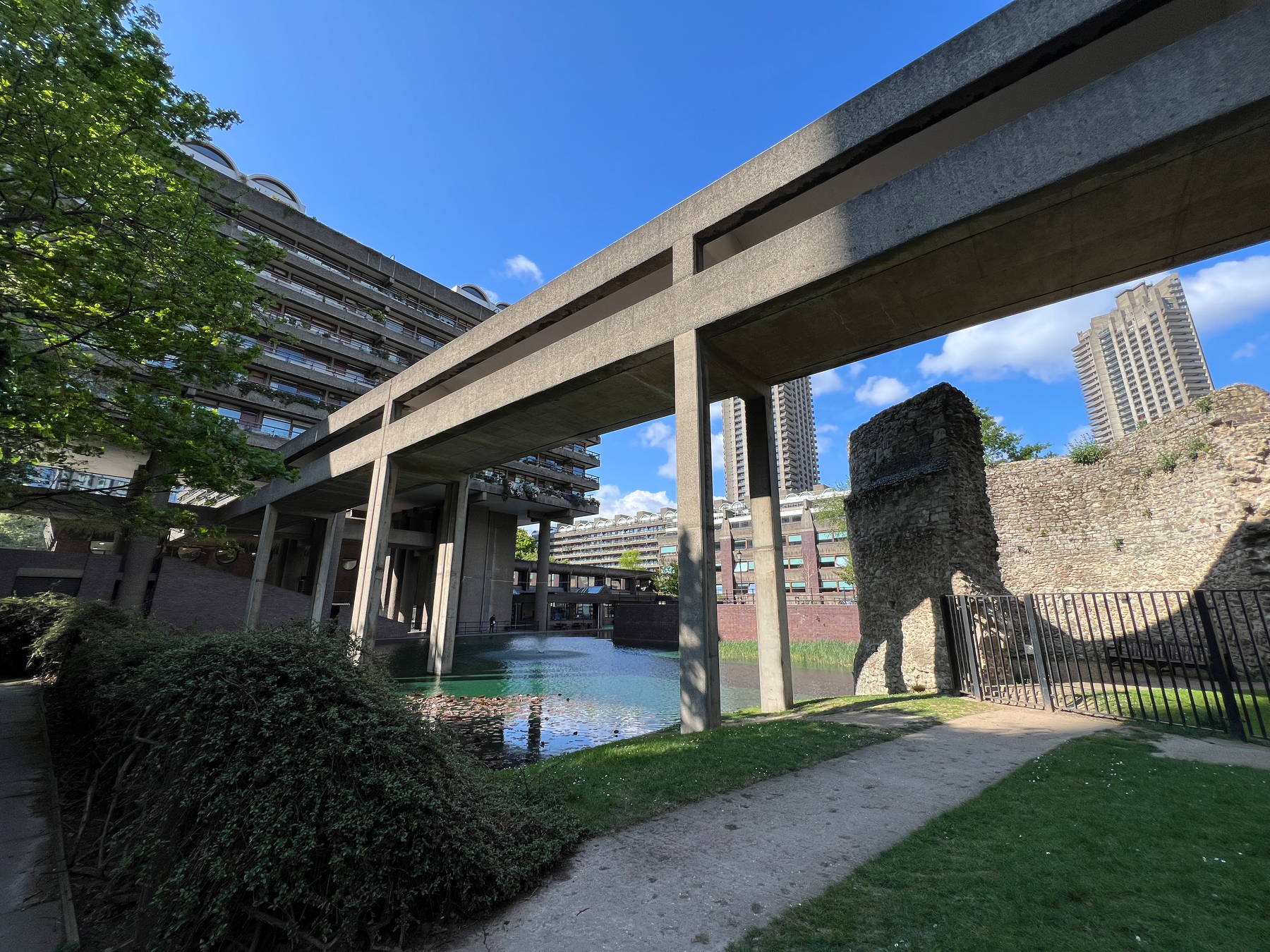 Some brutalist 1960s architecture above a pond and a crumbling corner of a Roman fort.