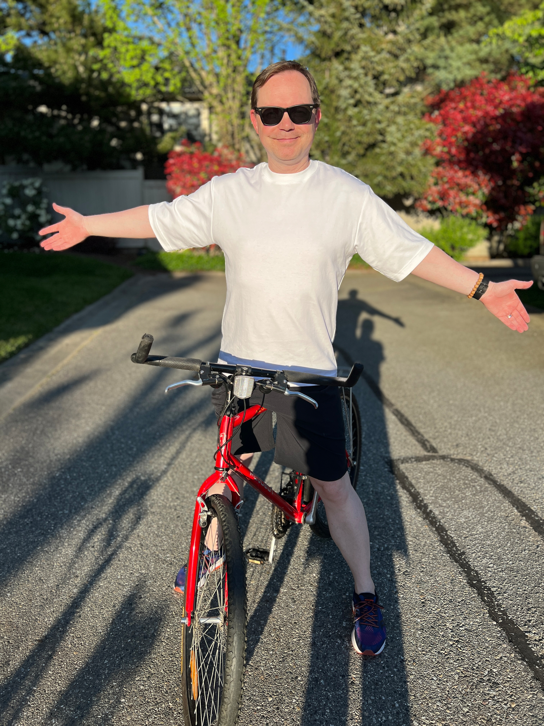Chad on his bike brandishing his pristine white top with a smile
