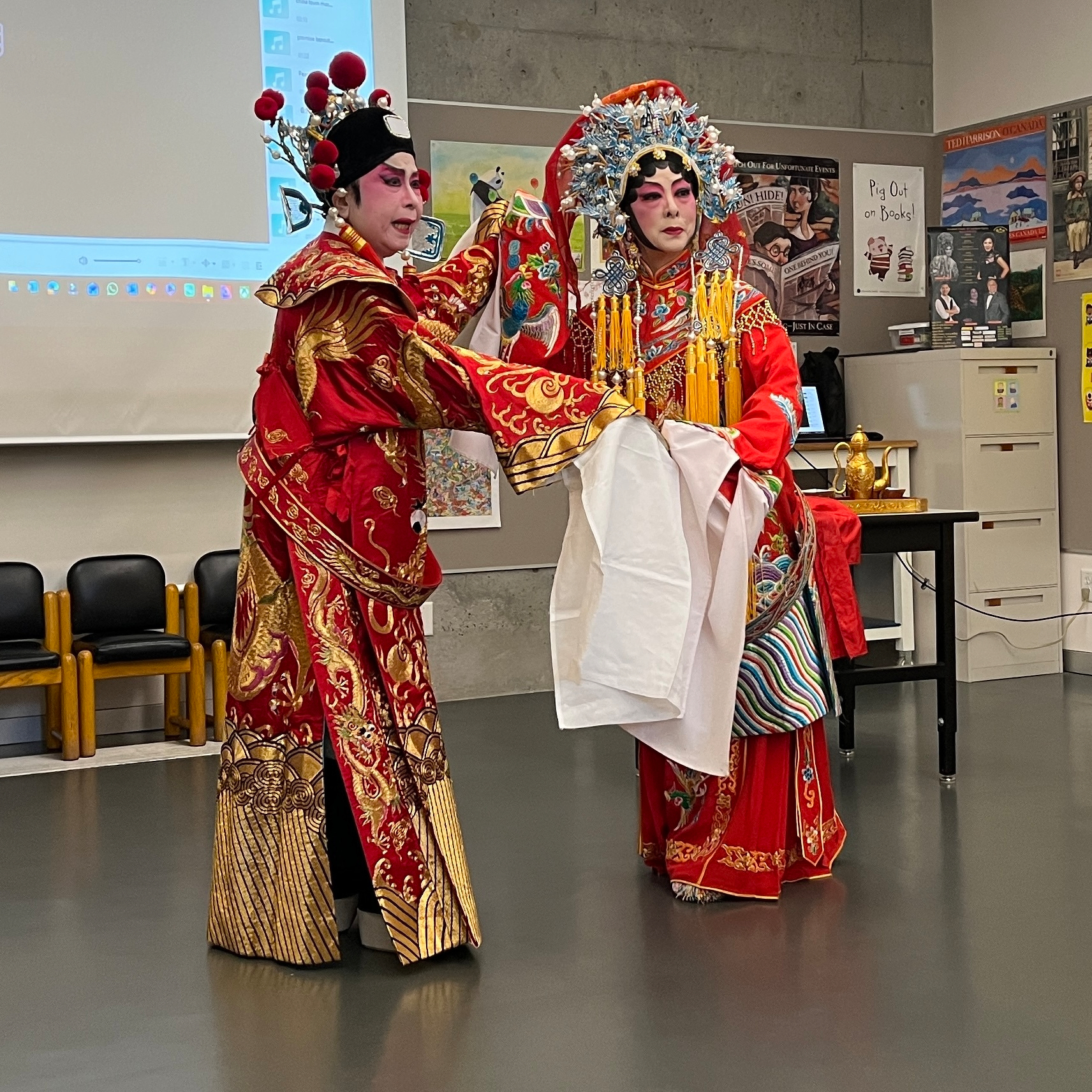 Two performers act out a scene of lovers drinking poison