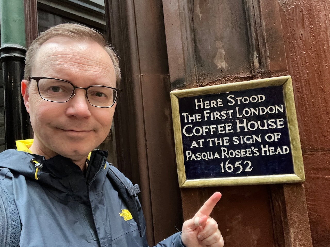 Chad points to a sign that says: HERE STOOD THE FIRST LONDON COFFEE HOUSE AT THE SIGN OF PASQUA ROSEE'S HEAD 1652