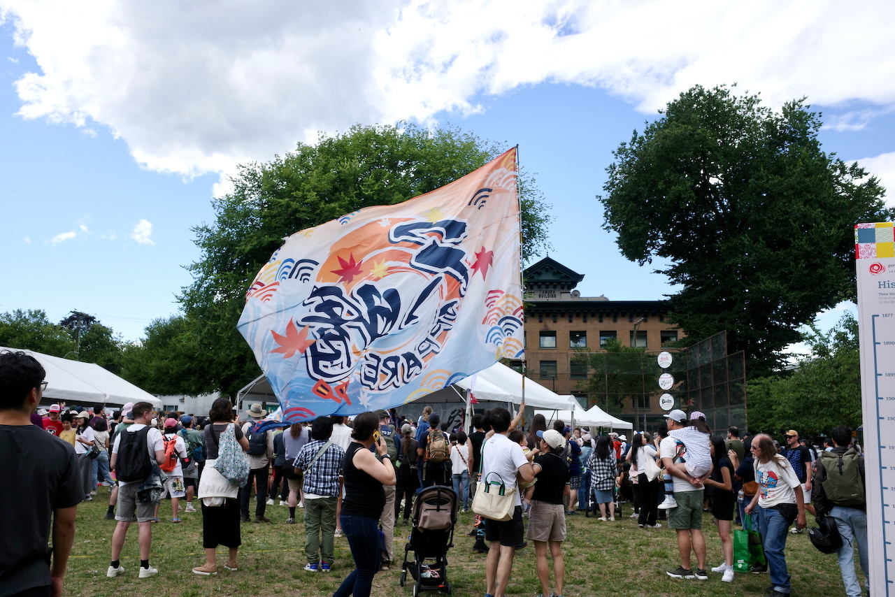 a massive decorated flag waving over a crowd