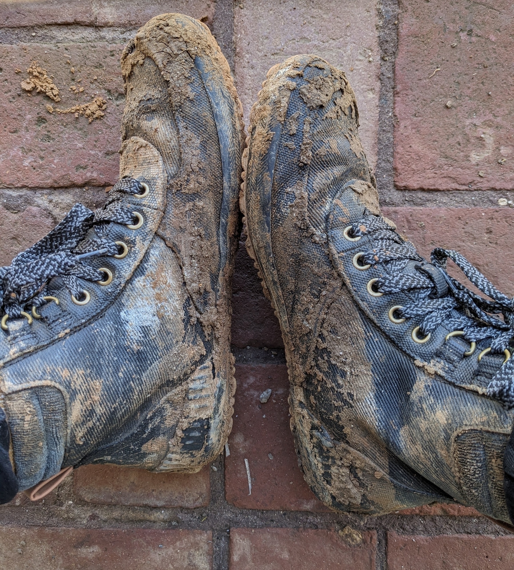 Photo of black hiking shoes covered in mud. 