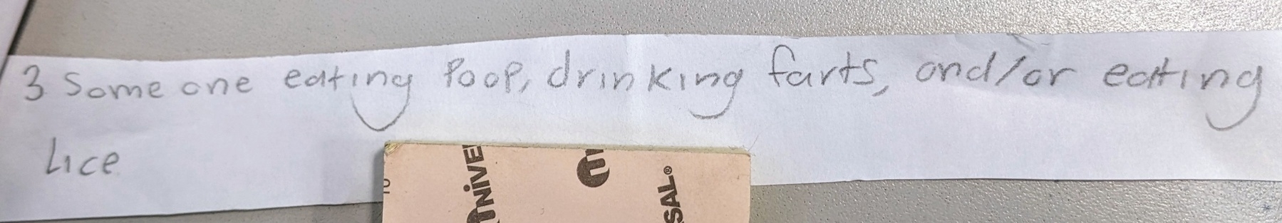 A photo of a strip of paper on a desk. The paper says, "3. Someone eating poop, drinking farts, and/or eating lice."