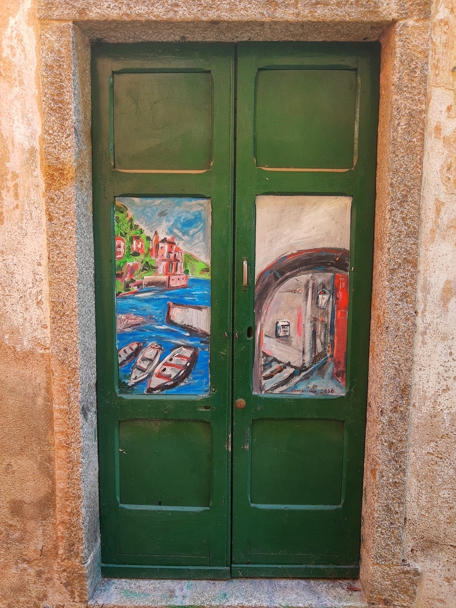 portone di ingresso in legno di colore verde con due dipinti disegnati sopra