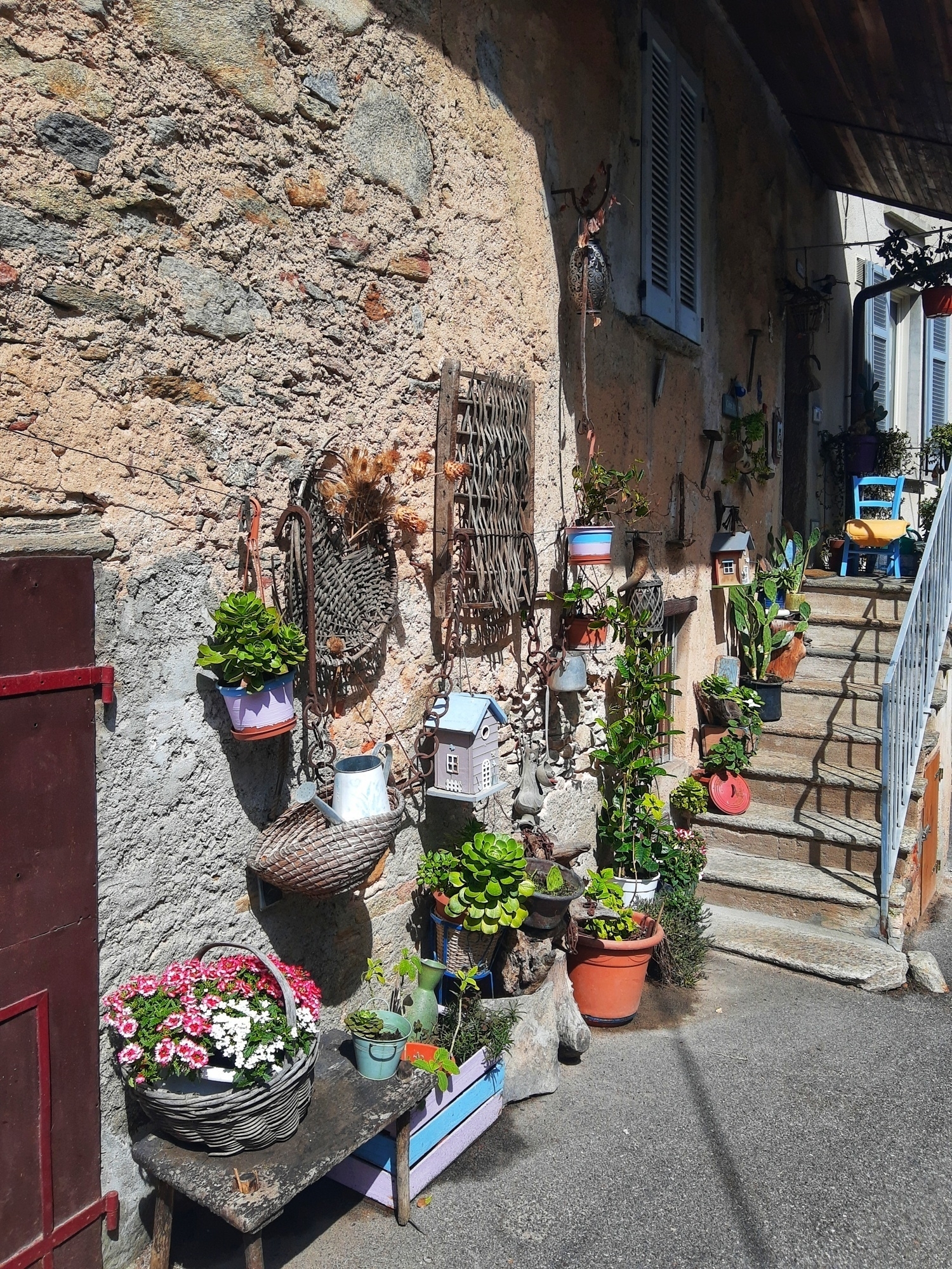 Ingresso di una cascina riattata con molti vasi di fiori colorati ecc alto abbellimenti