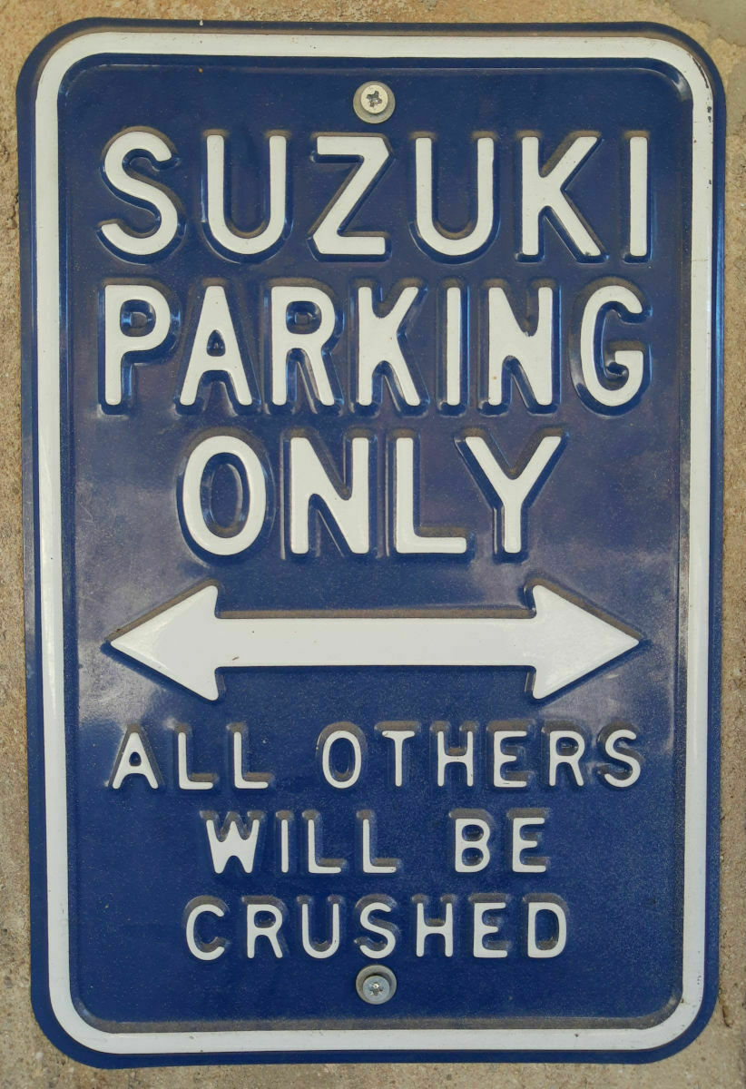 Cartello con scritta bianca su sfondo blu ed in lingua inglese: Suzuki parking only. All others will be crushed
