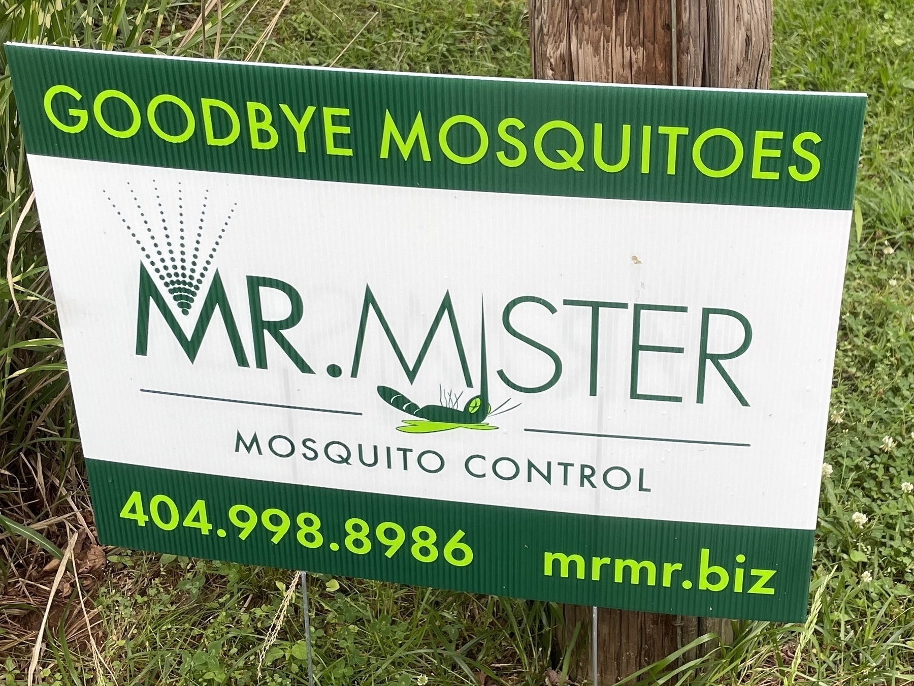 A yard sign advertising a lawn mosquito treatment service. The company is called Mr. Mister, and the sign shows a drawing of a dead mosquito. 