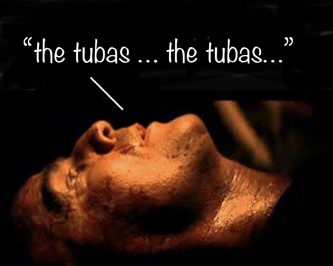 Scene from apocalypse now showing Colonel Kurtz (Marlon Brando)‘s face,  dying, lying on his back with eyes open but instead of saying “the horror the horror” he’s saying “the tubas … the tubas”