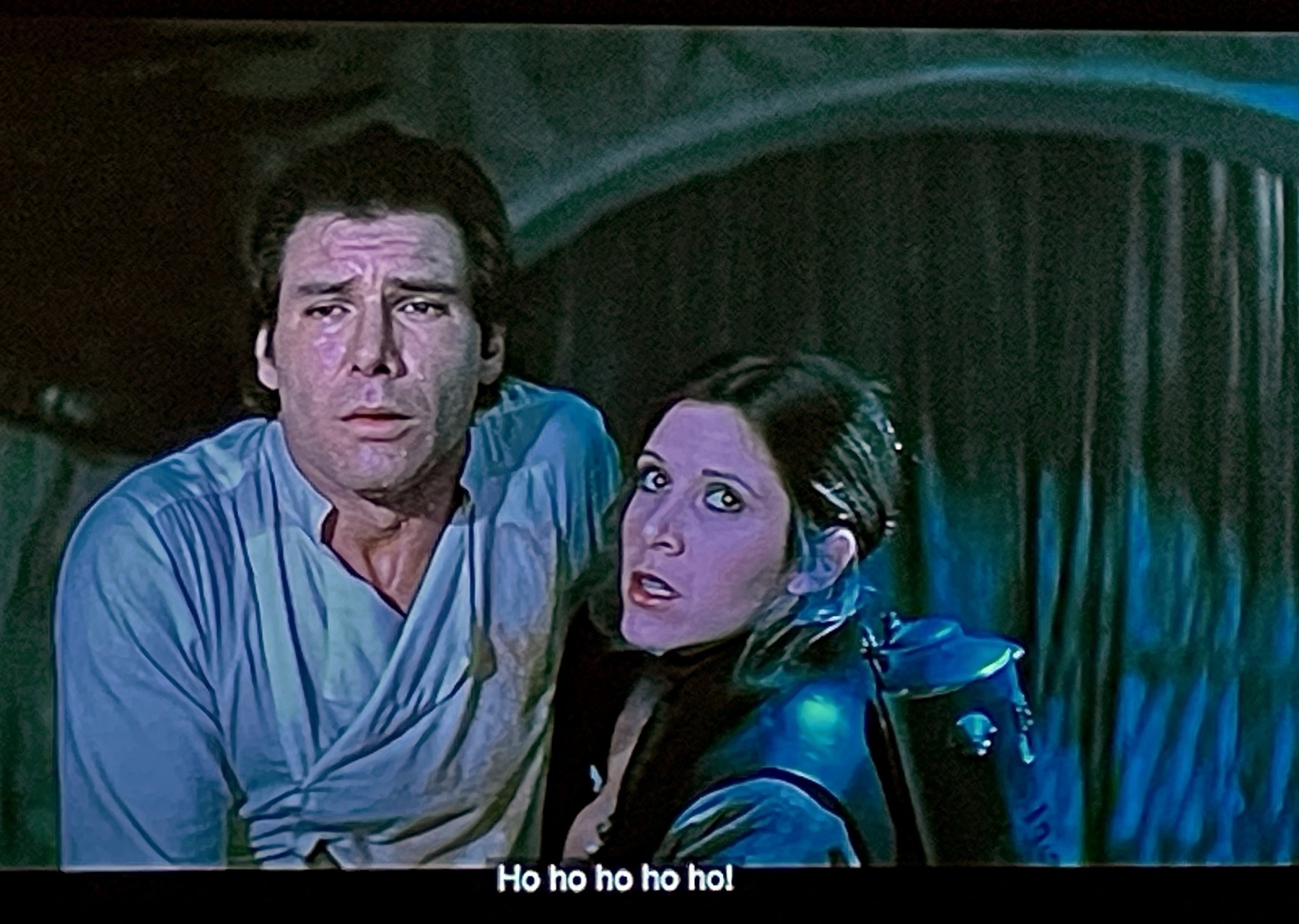 A scene from Return of the Jedi where Leia is reviving Han in Jabba’s lair, but you hear Jabba victory-chortling “ho ho ho ho ho” with the closed caption spelling it out at the bottom of the frame 