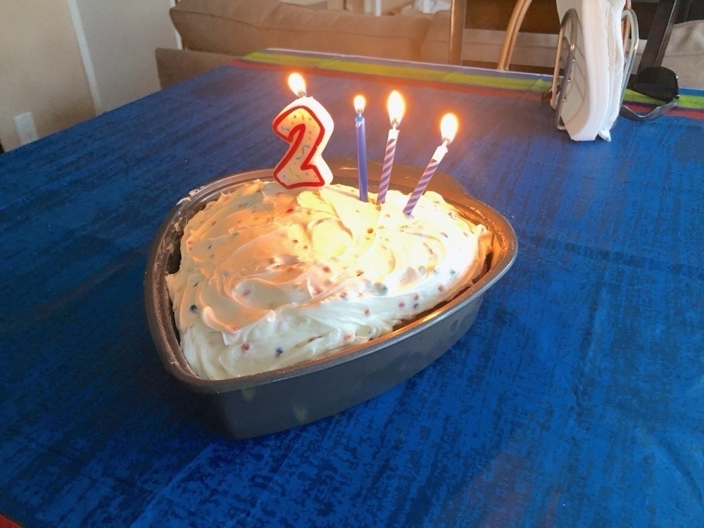 A homemade birthday cake with candles for a 23rd birthday.