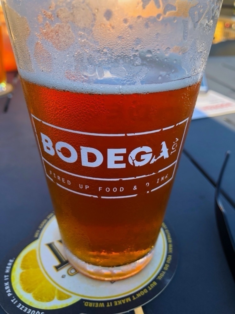 Closeup of a glass of beer with the word Bodega on the glass