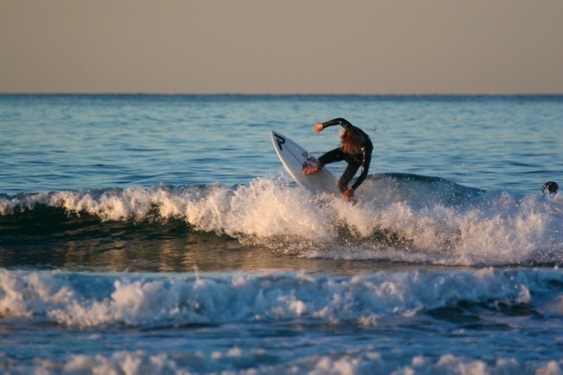 A surfer is performing a maneuver on a wave in the ocean.