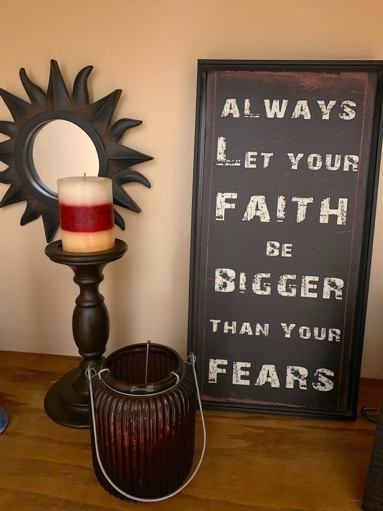 An inspirational poster with candle and mirror.