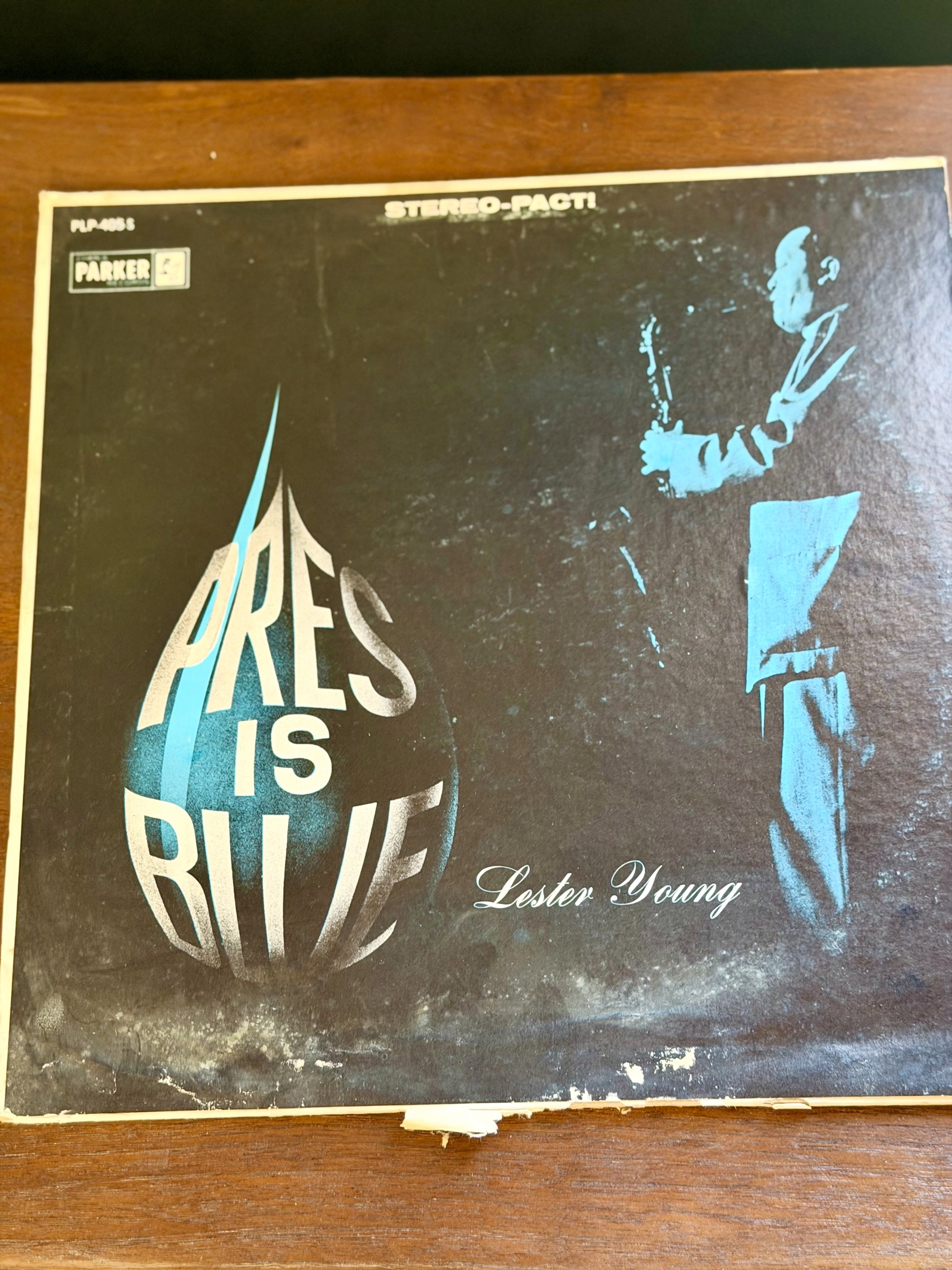The album cover features a blue silhouette of a man playing a saxophone with the text PRES IS BLUE in white in a blue teardrop and Lester Young prominently displayed.
