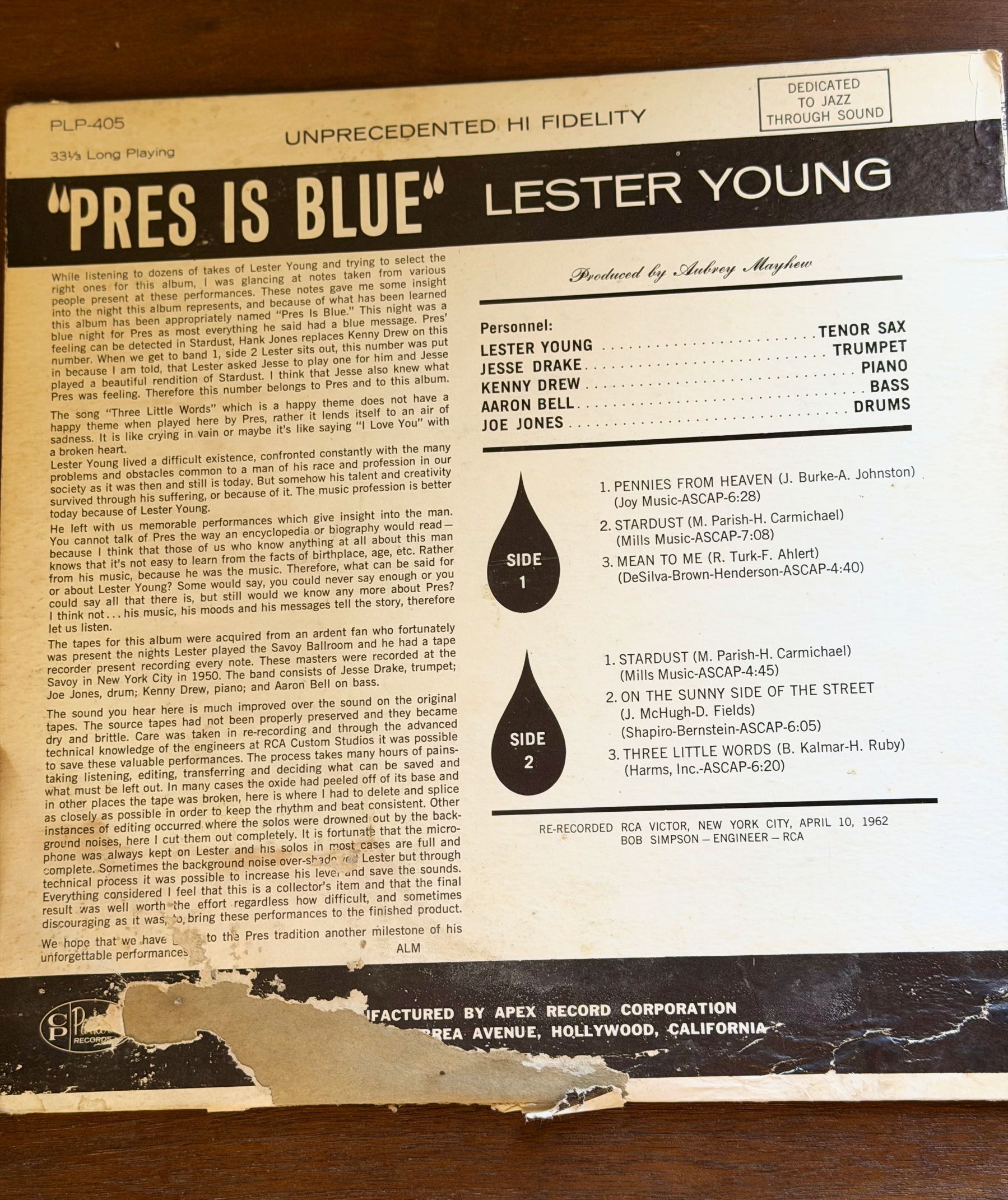 A vintage vinyl record sleeve features the album Pres Is Blue by Lester Young, detailing the personnel, tracklist, and production notes. Moderate damage along the lower portion of the sleeve.