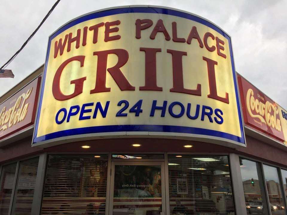 A diner named White Palace Grill with a large sign indicating it is open 24 hours is shown.