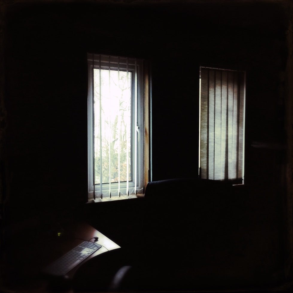 two windows in a darkened room