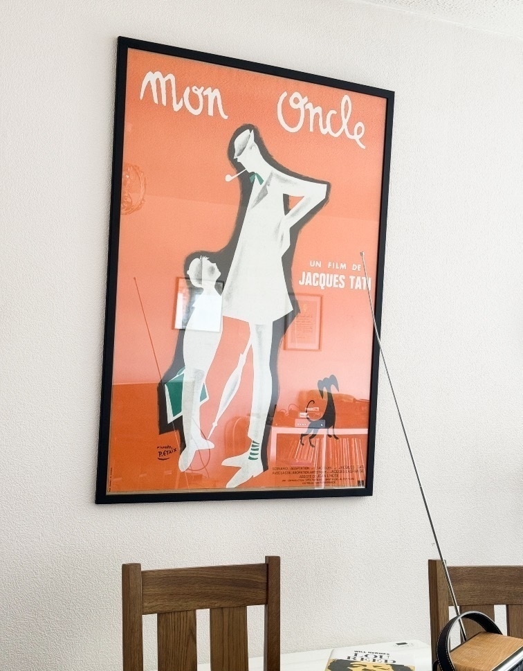 A framed poster for the film Mon Oncle (directed by Jacques Tati) hanging on a wall.