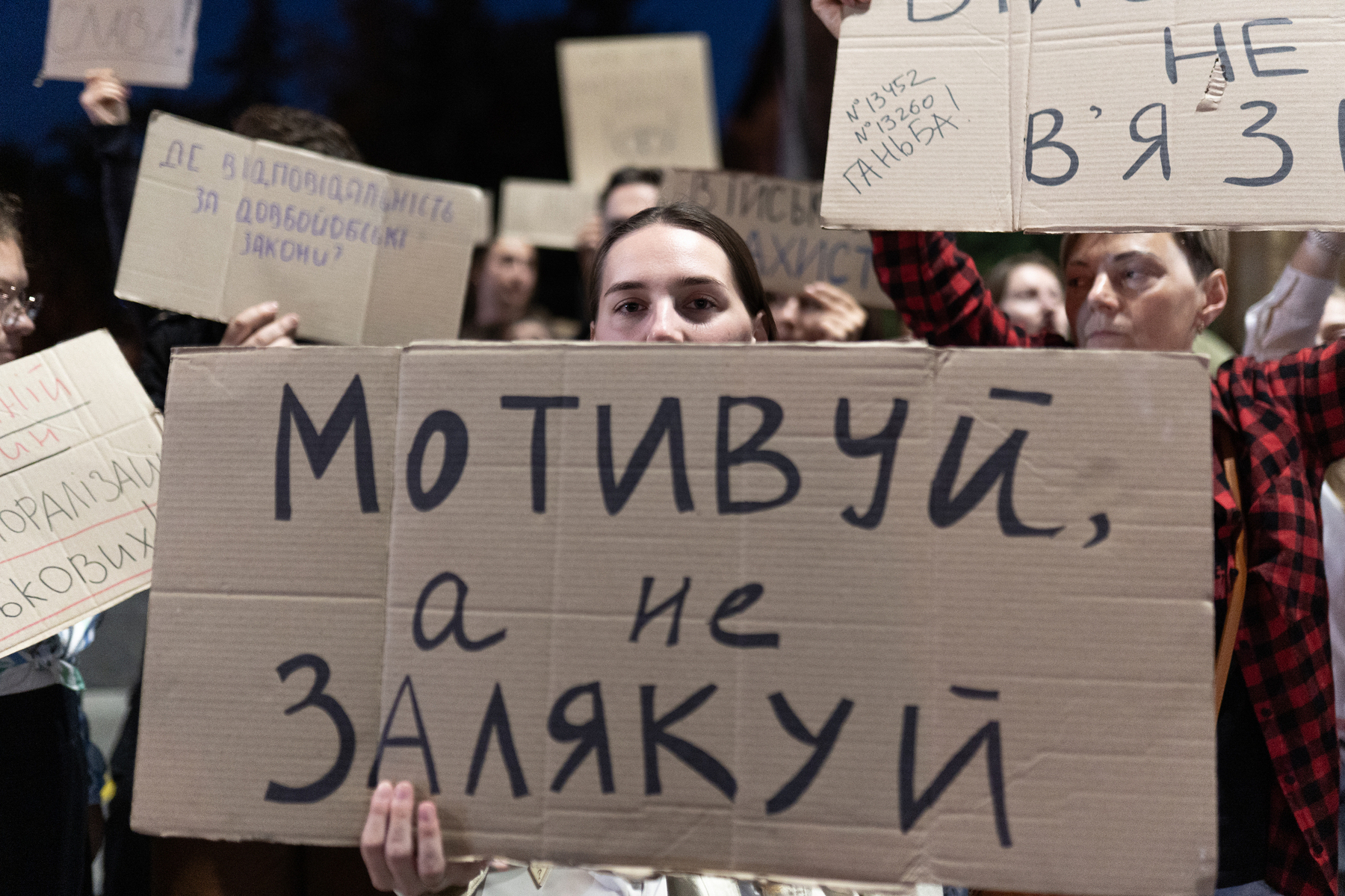 A protester holding a sign reading “Motivate, don't intimidate” at a protest in Kharkiv on September 7
