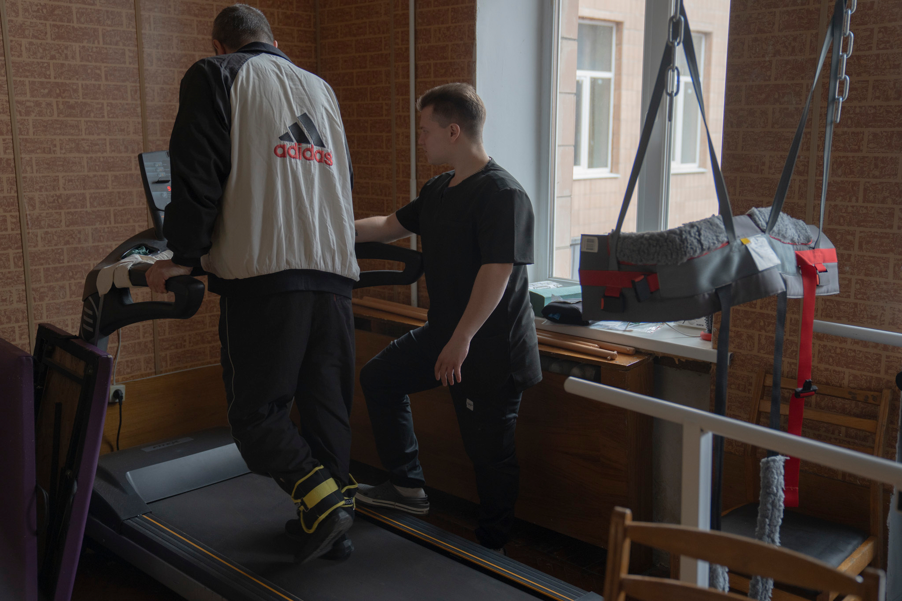 A veteran exercises on a simulator with a rehabilitation specialist