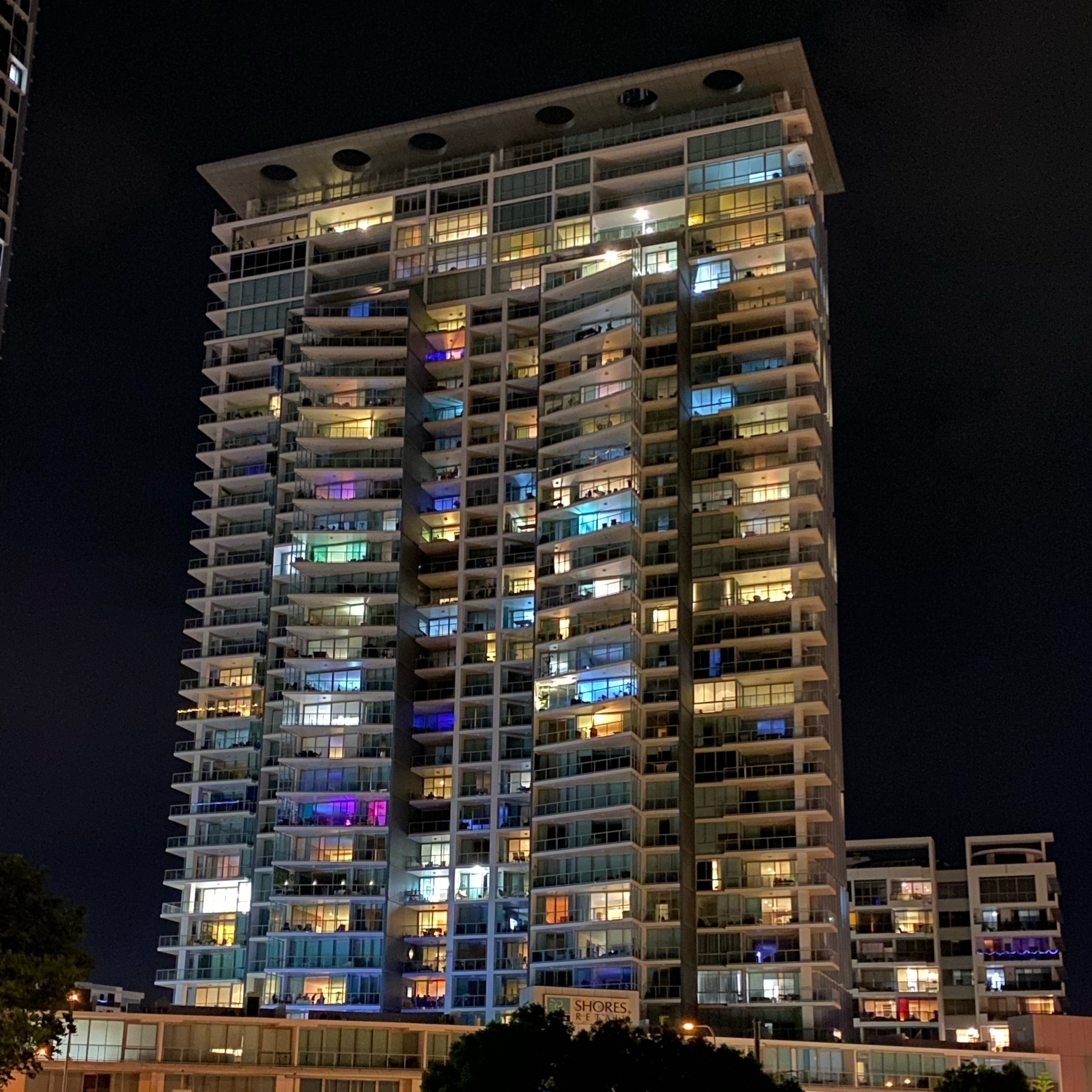 apartment tower at night with different colour lights. 