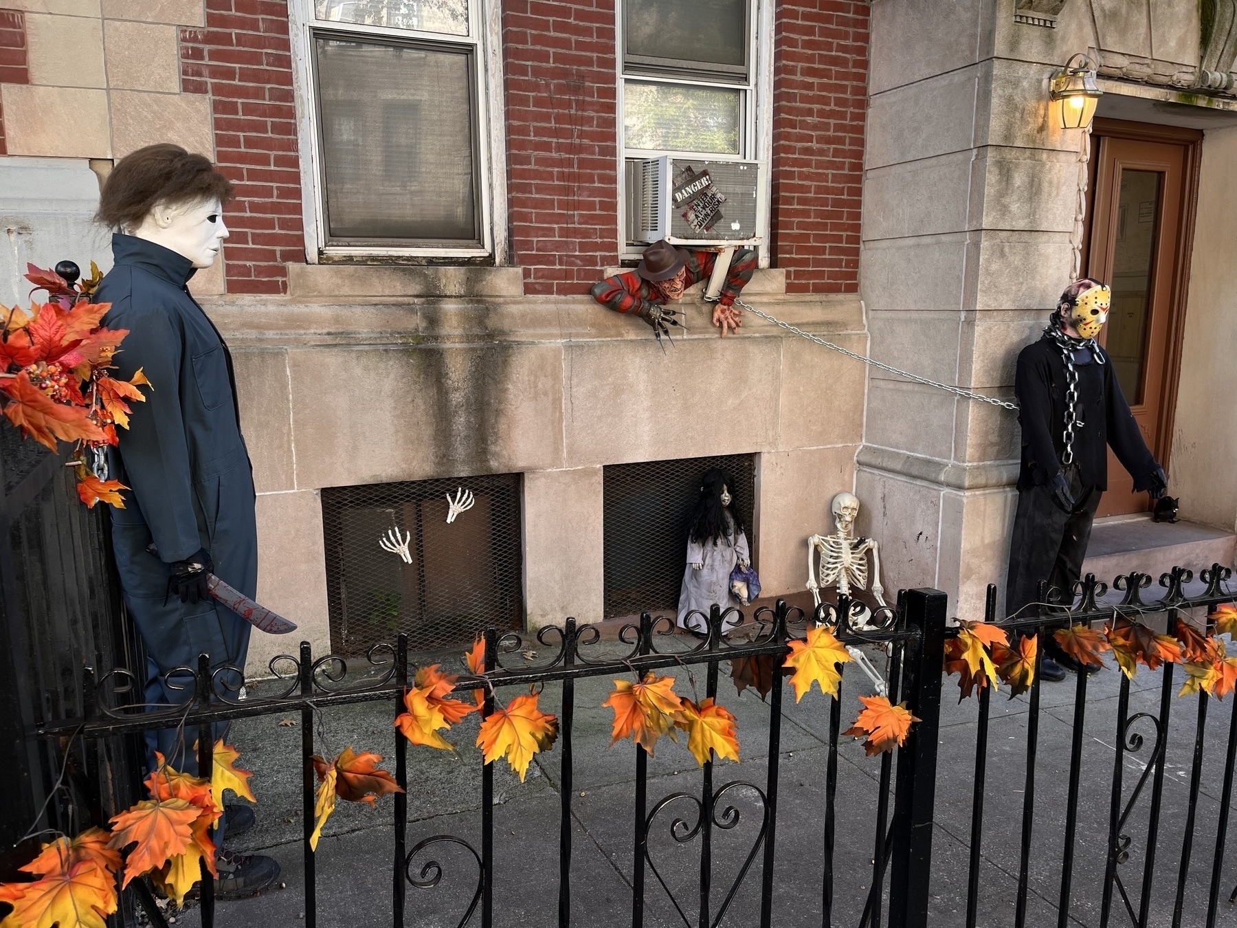 An apartment building with life sized Michael Myers, Jason chained to Freddy coming out the window. 