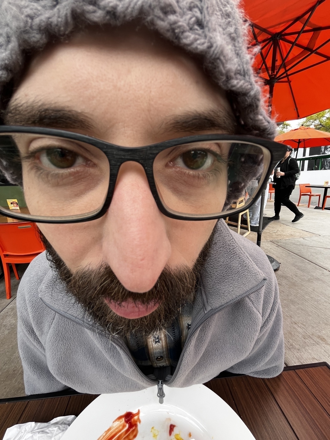 Extreme close up angle of me, a whir man with beard and glasses. The angle makes my eyes look huge and my chin taper into a tiny point. 