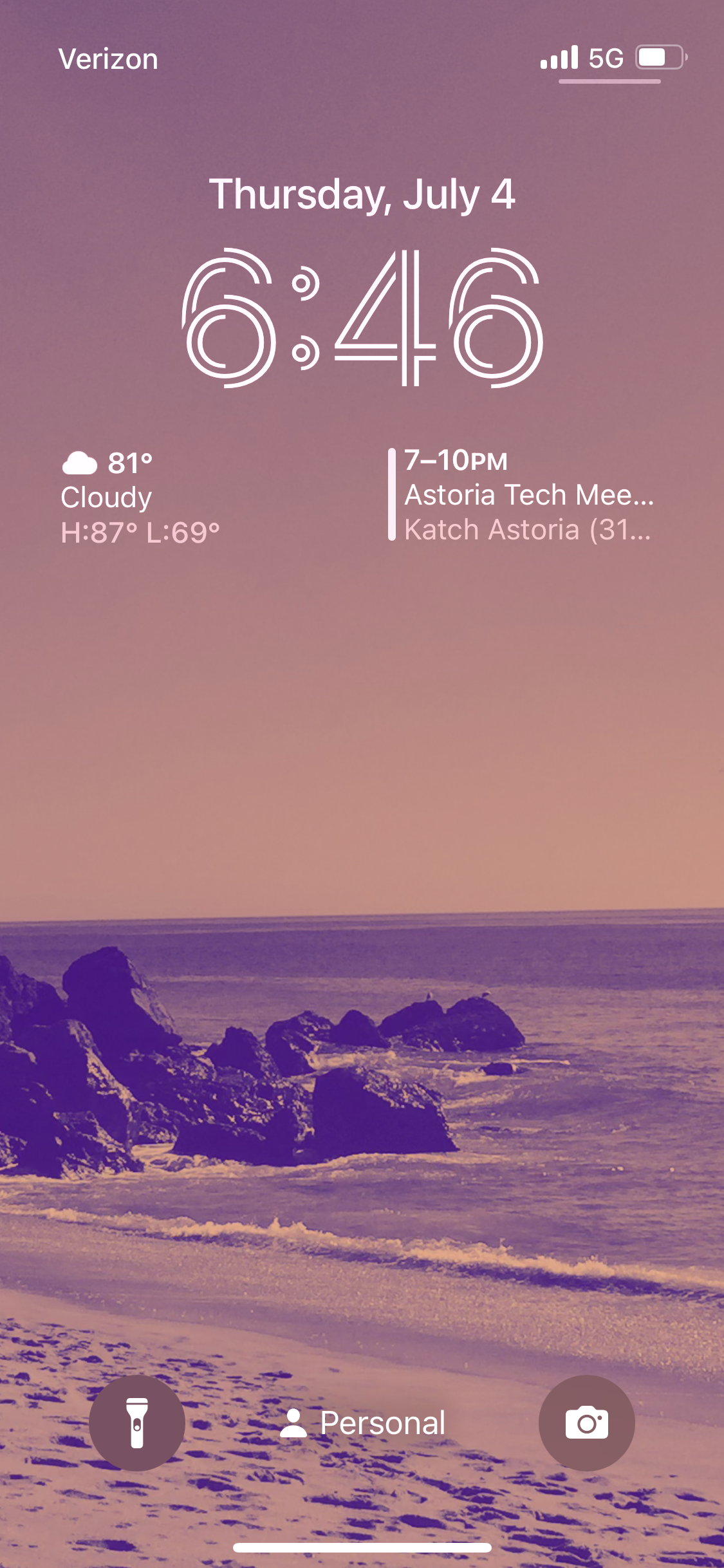 A purple tinted rocky beach iOS Lock Screen. 