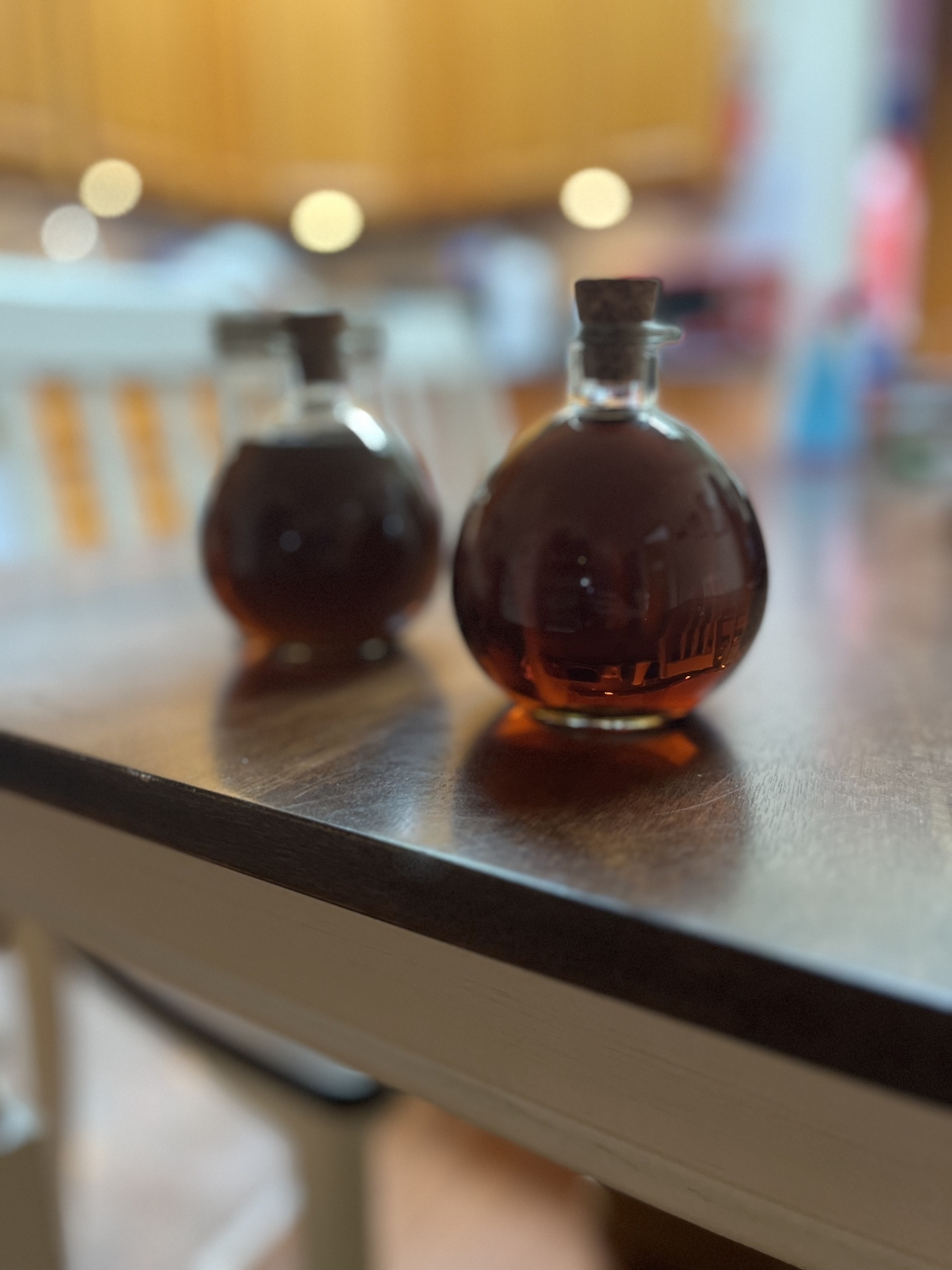 Two round glass bottles with corks containing a dark brown liquid. 