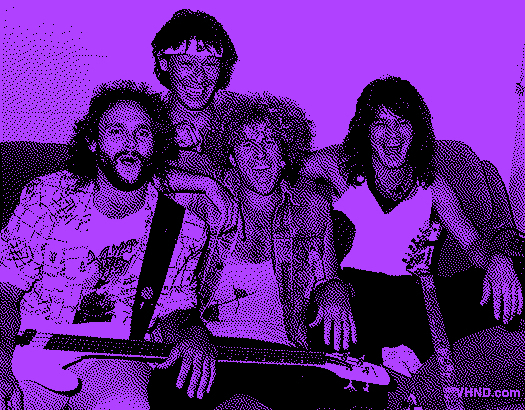 Grainy black and white photo of members of Van Halen with Sammy Hagar in the mid 80s. They're all laughing on a couch.