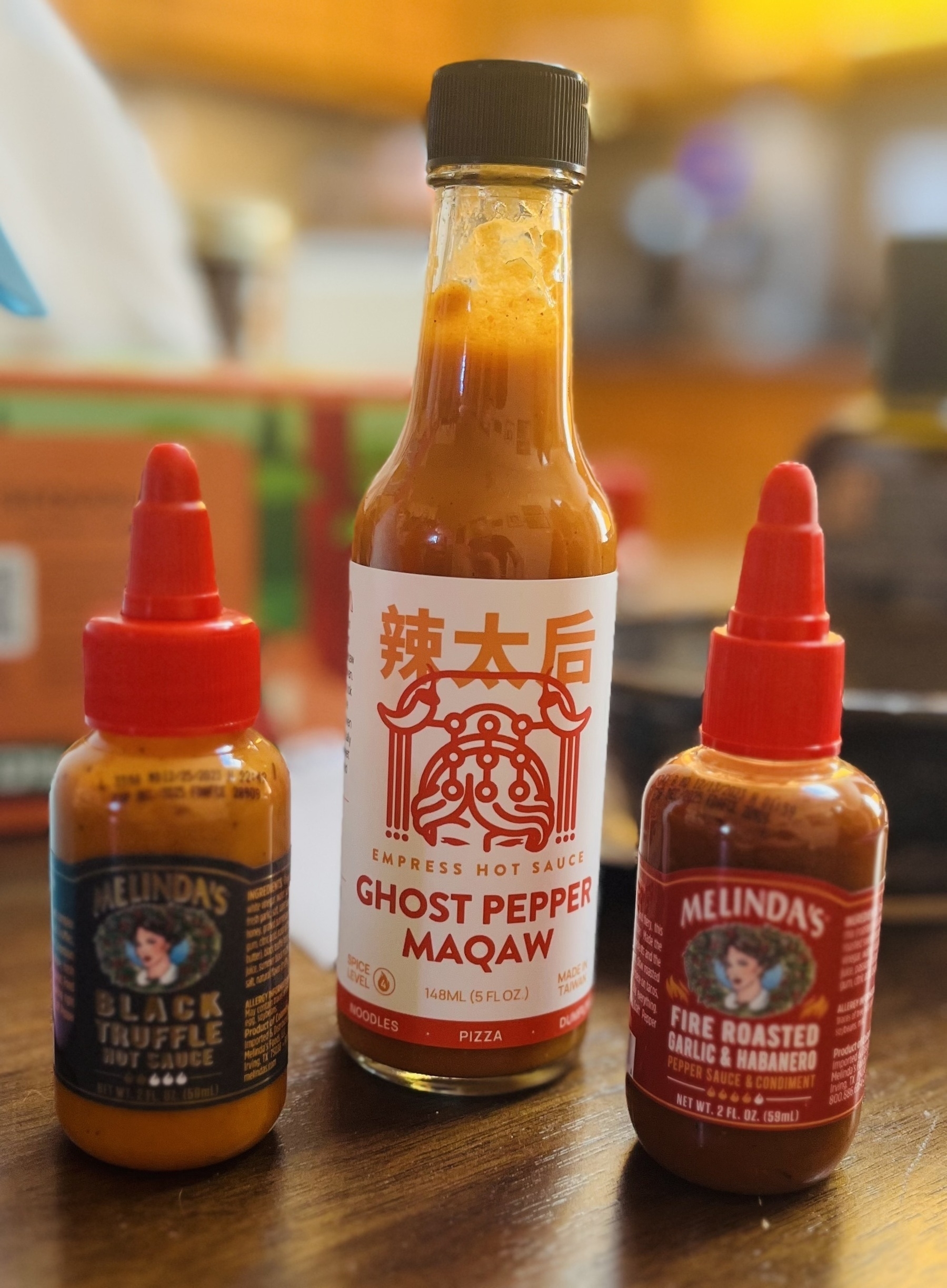 Three bottles of hot sauce. Empress ghost pepper maqaw, and Melinda’s black truffle a d fire roasted garlic and habanero. 