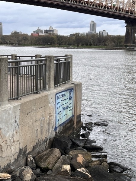 Graffiti on the side of a pier that looks like a postcard. Most of the text is intentionally illegible, but to phrases are clear: "Dear mom" and "I'm done!"