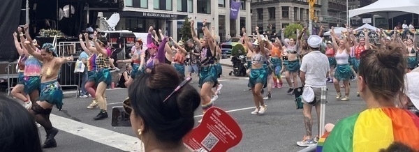 A group of LGBTQ+ dancers in mid performance. They radiate love and joy.