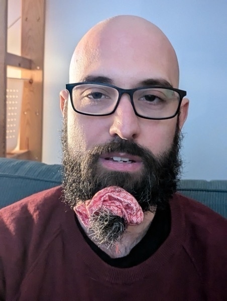 Me, a bald whte man with a beard and glasses. I have a big patterned scrunchie tying my beard.