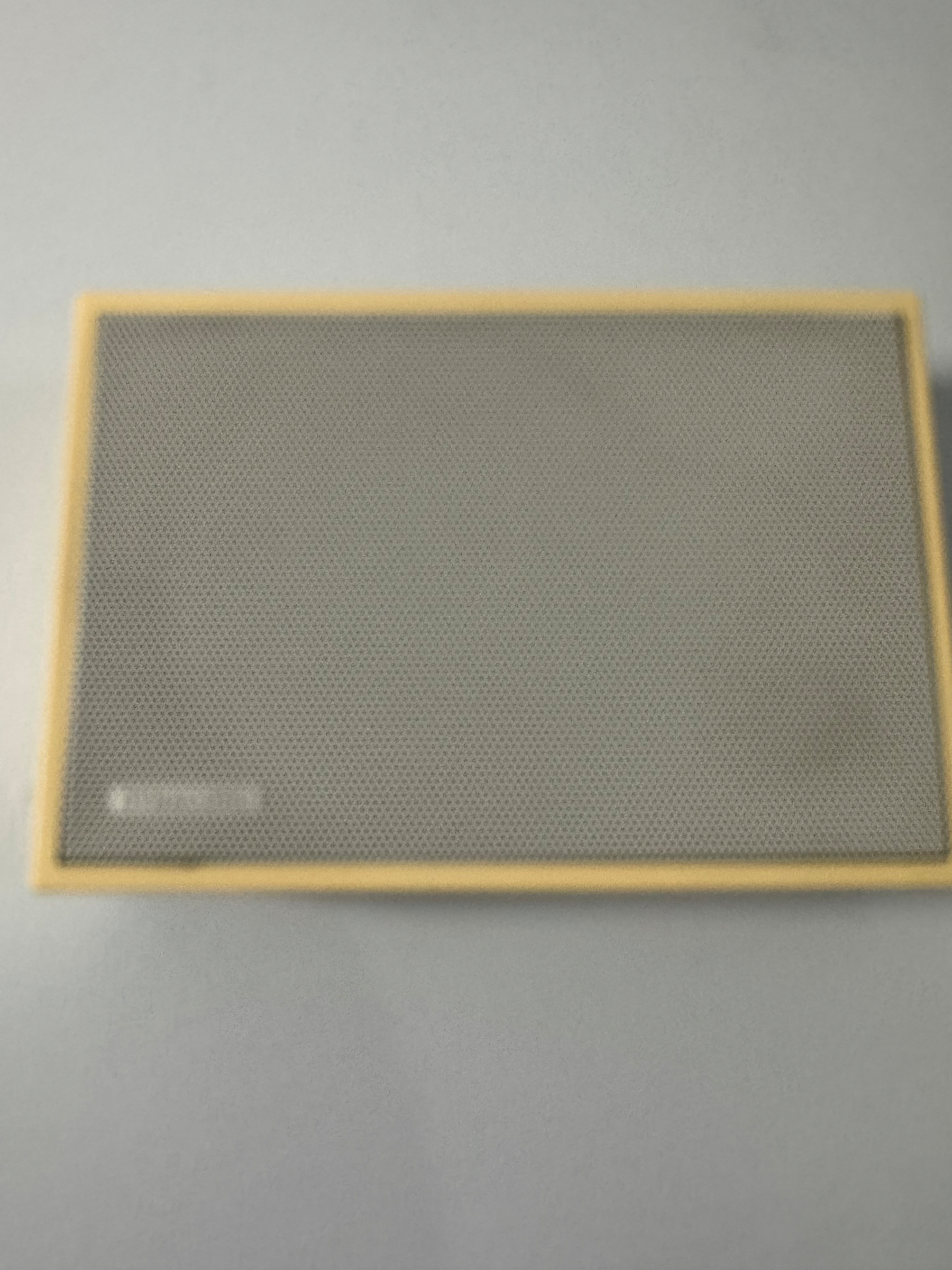 A rectangular speaker with a mesh front and a light-colored frame is displayed.
