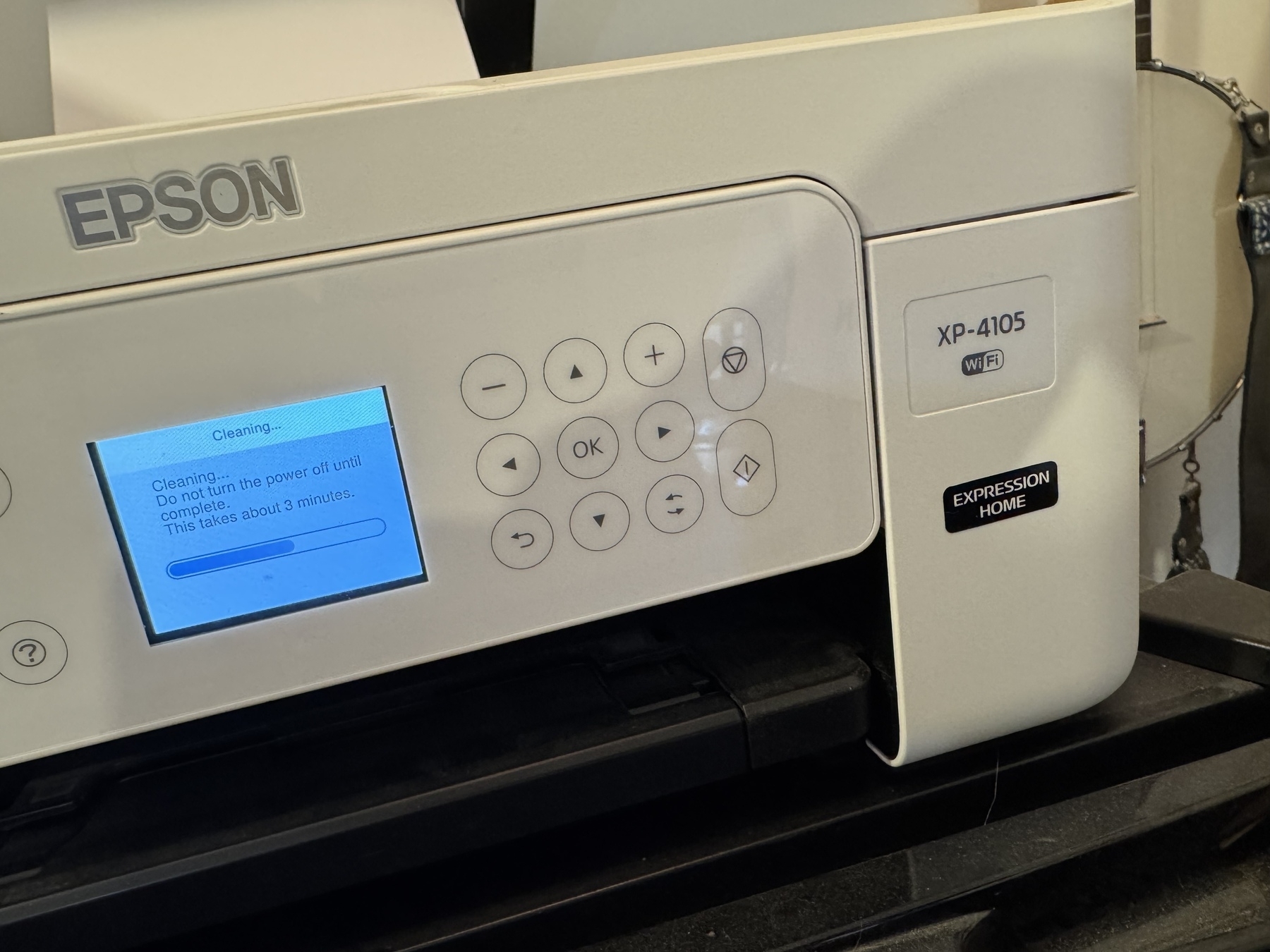 An Epson printer, model XP-4105, is actively displaying a cleaning process on its screen.