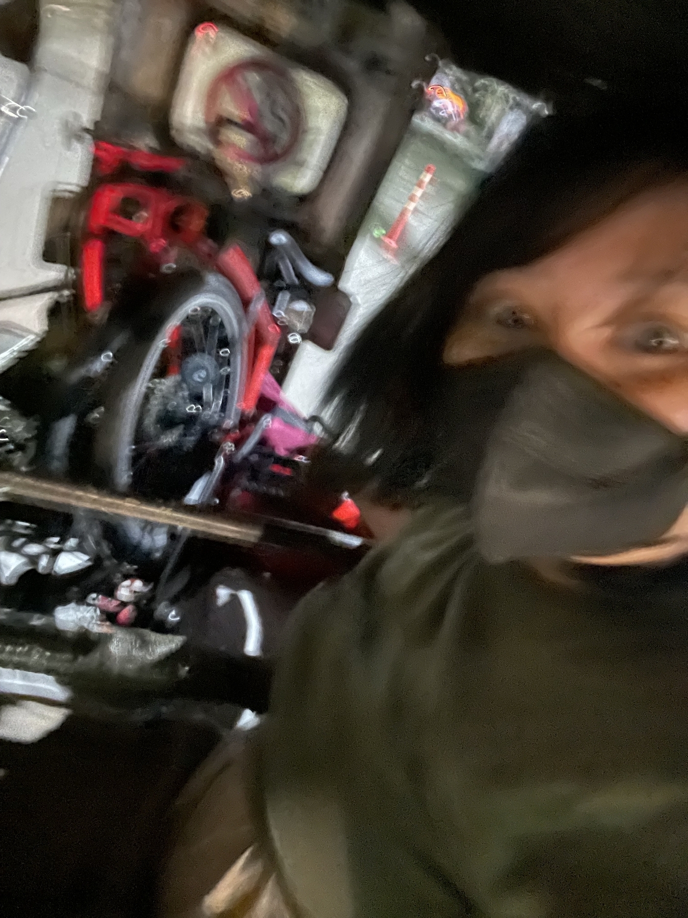 A selfie of Chi wearing a mask and at the back of a tricycle, while holding onto her folded folding bike which was neatly tucked in the inner seat of the tricycle. It’s a bit blurry because it’s dark and the only source of light for the photo is the occasional streetlight.