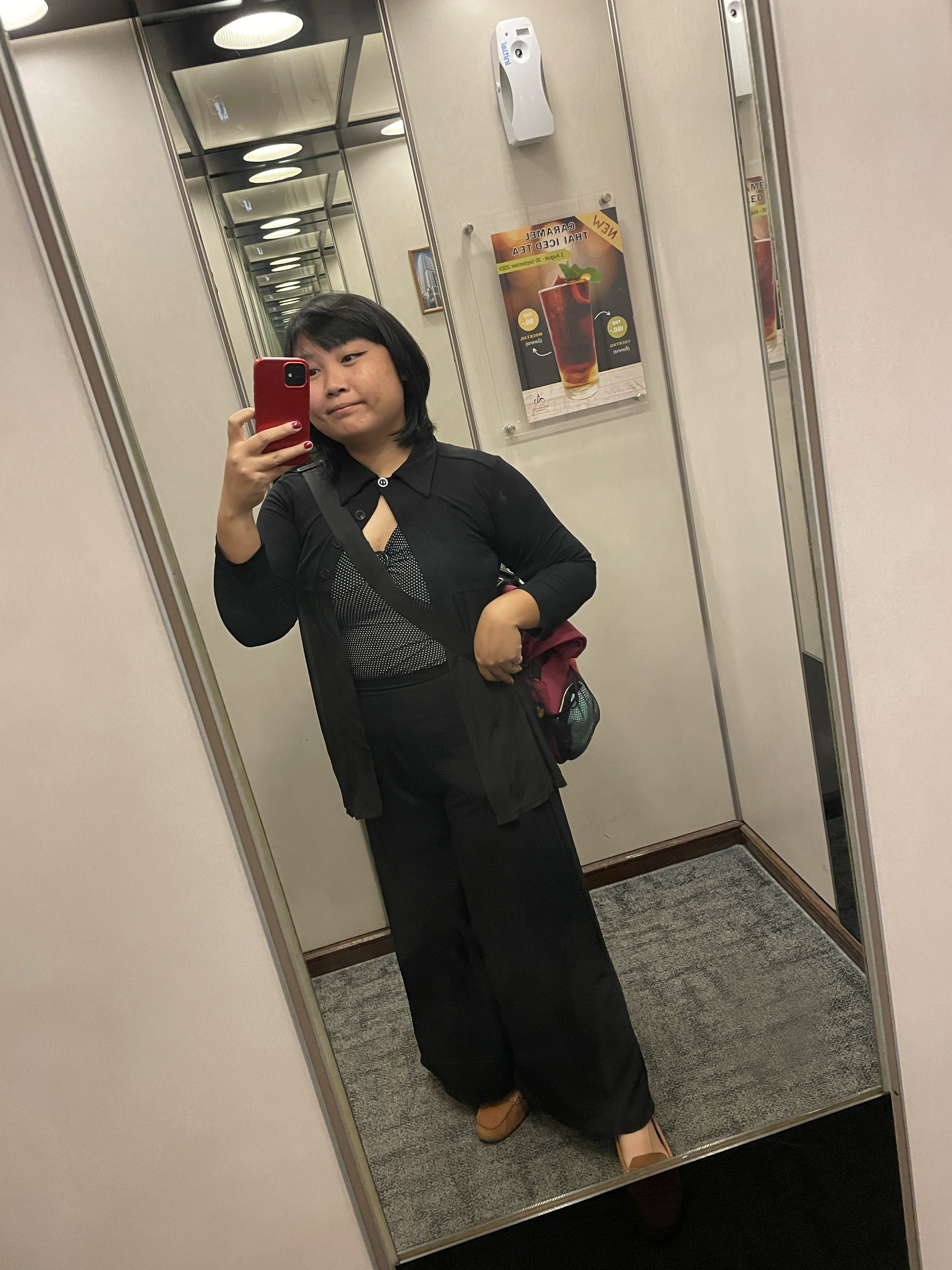 Chi’s outfit for the day shown in a mirror selfie: white polka-dot on black v-neck fitted top with a sheer black long sleeved collared coverup, and long black flared pants.