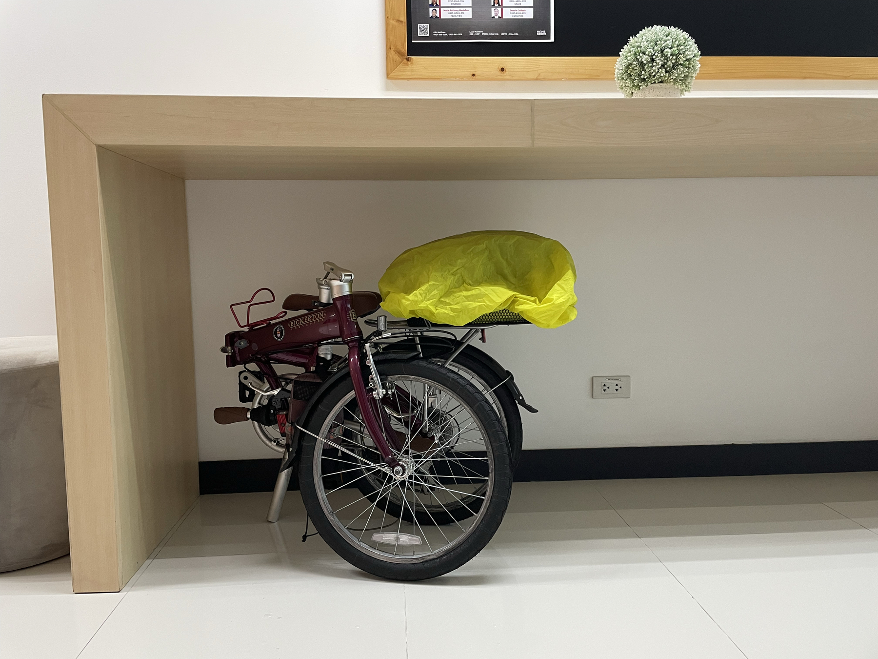 Chi’s folding bike neatly tucked under a wall table