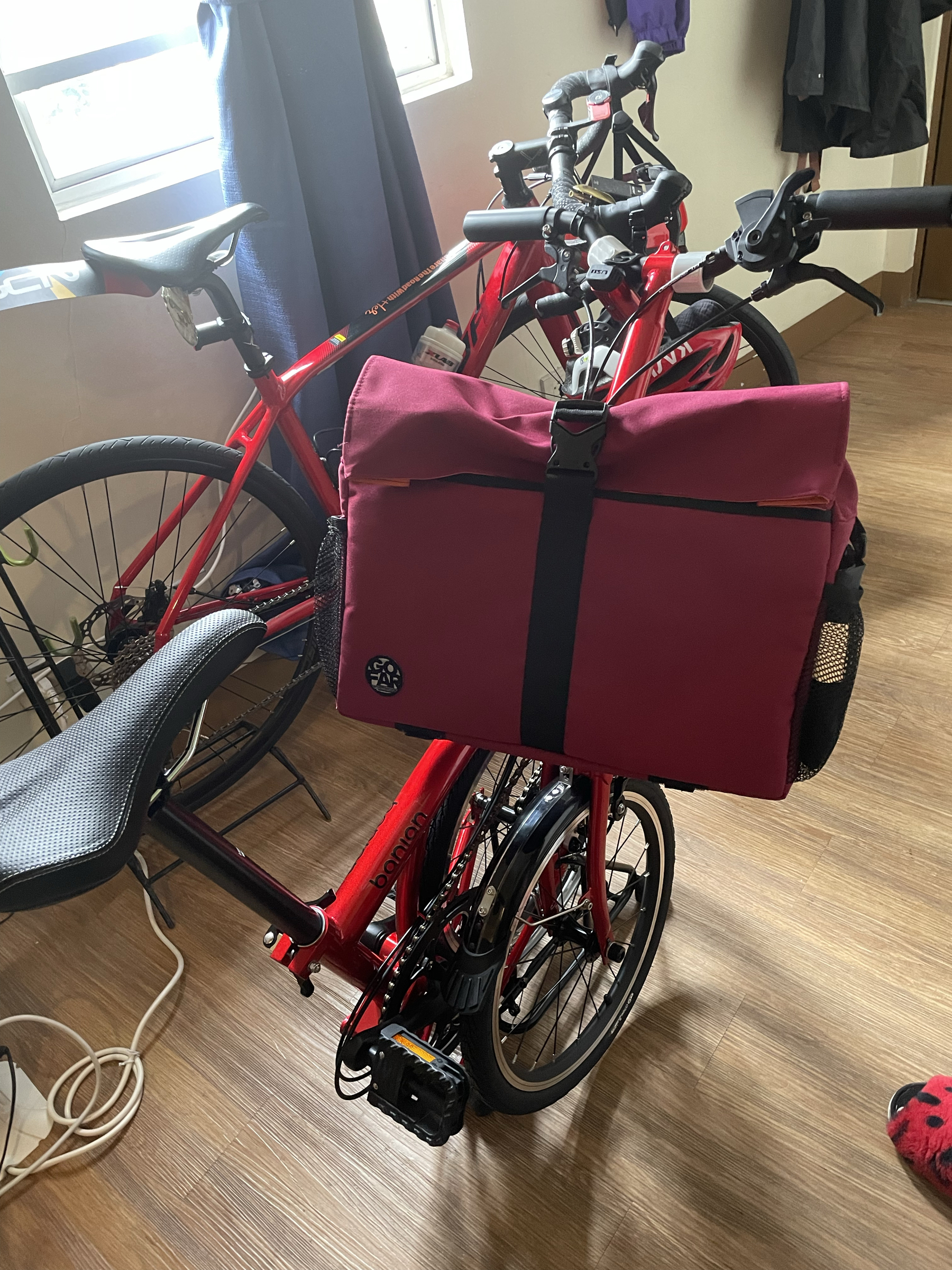 photo of Chi’s trifold bike folded into the trifolded state, with a front bag still neatly attached and doesn’t seem to hinder bringing it around