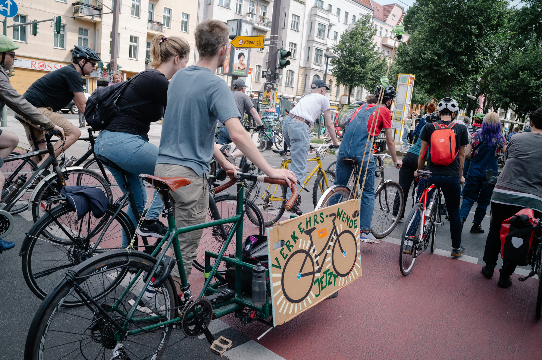 A snapshot of a bike protest, the focal point is a sign that reads “Verkehrswende Jetzt”