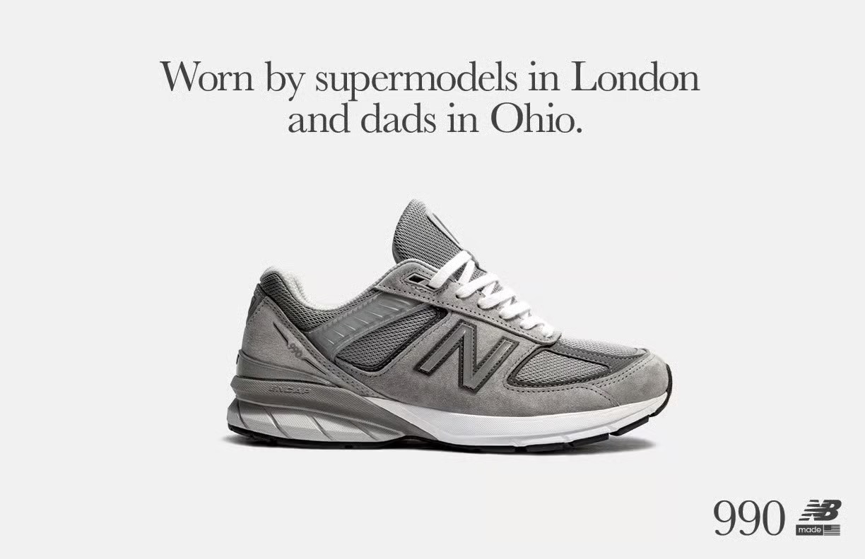 A gray New Balance 990v5 sneaker is displayed with the caption, Worn by supermodels in London and dads in Ohio.