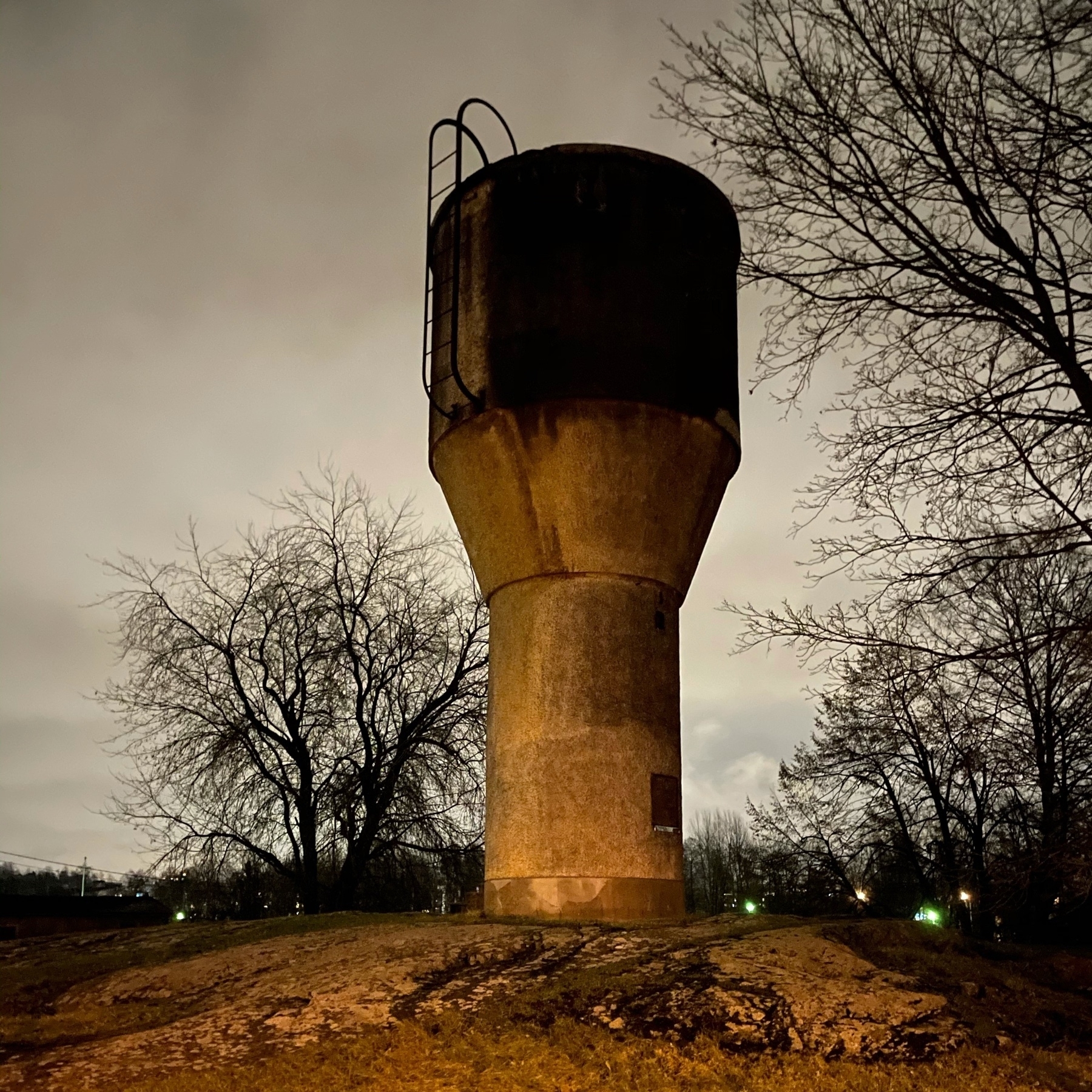 small concrete water tower in dark