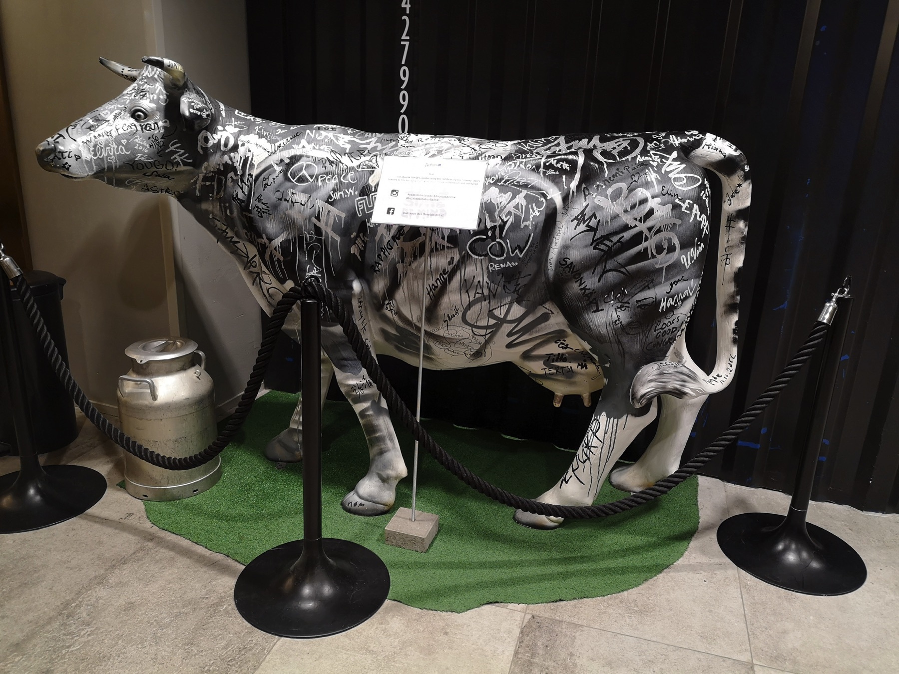 totally unrelated statue of a cow with graffiti