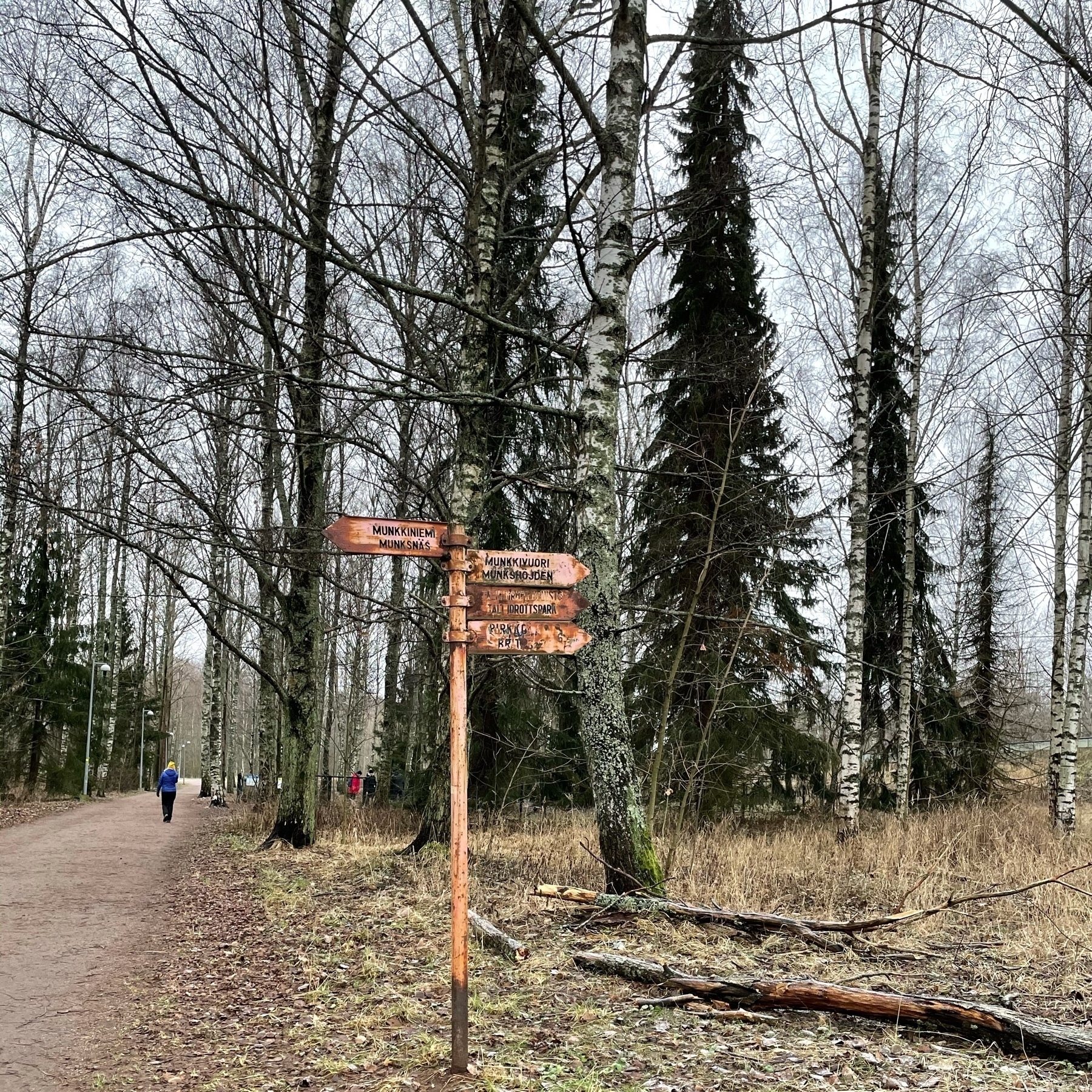 rusty signpost pointing to munkkiniemi and tali