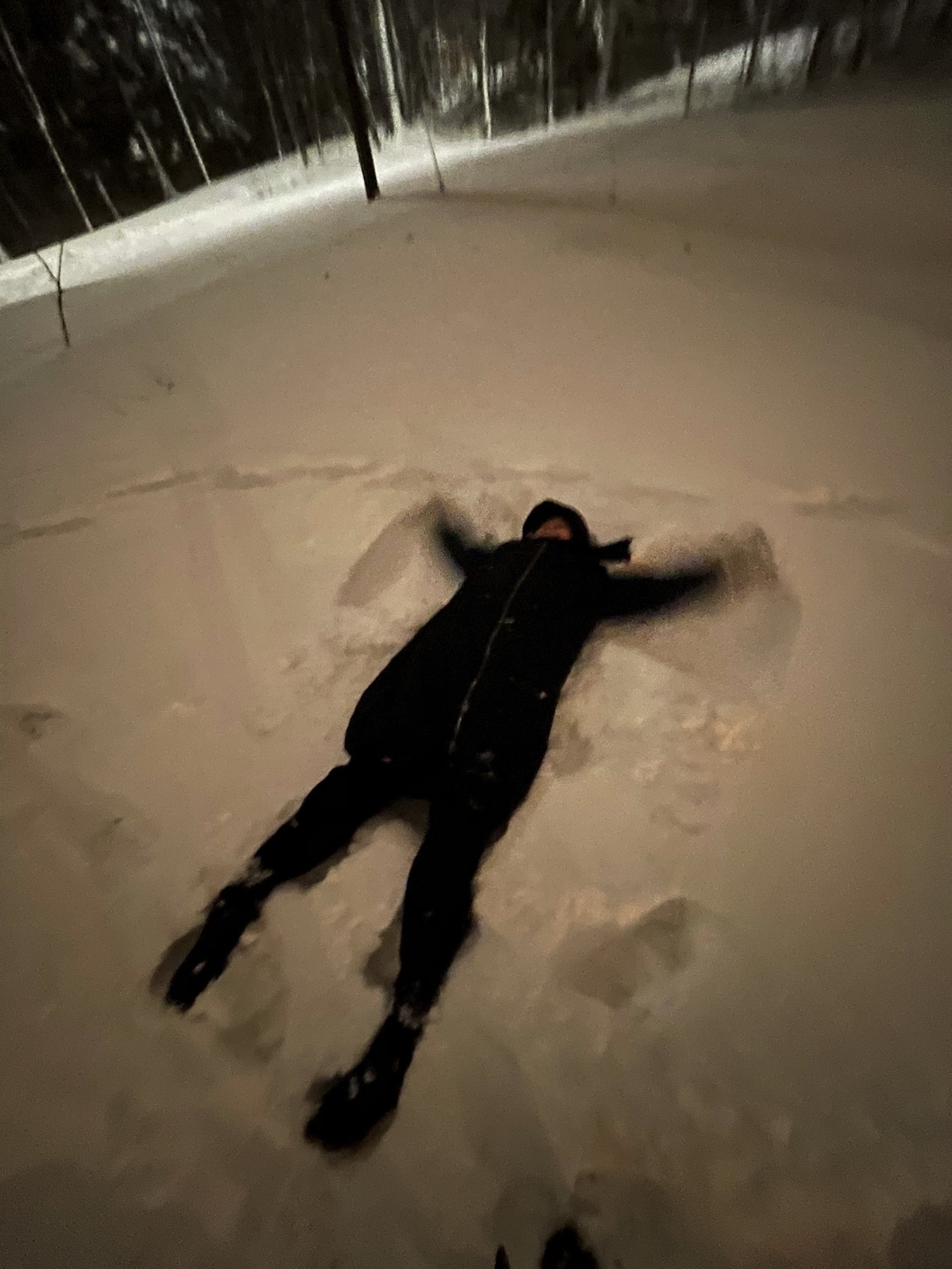 woman doing snow angels in deep snow