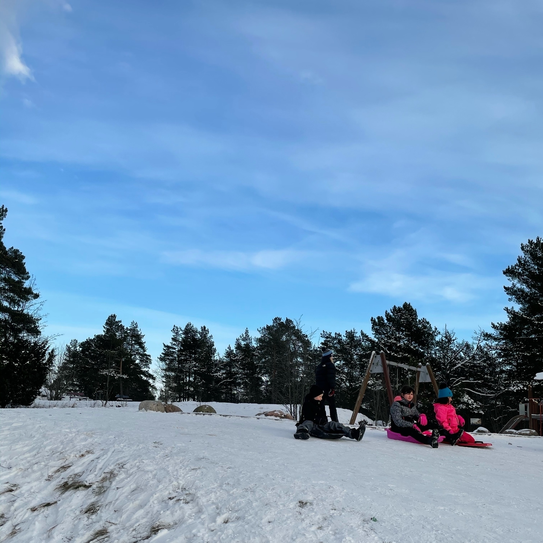 multiple kids waiting for their turn to slide down the hill