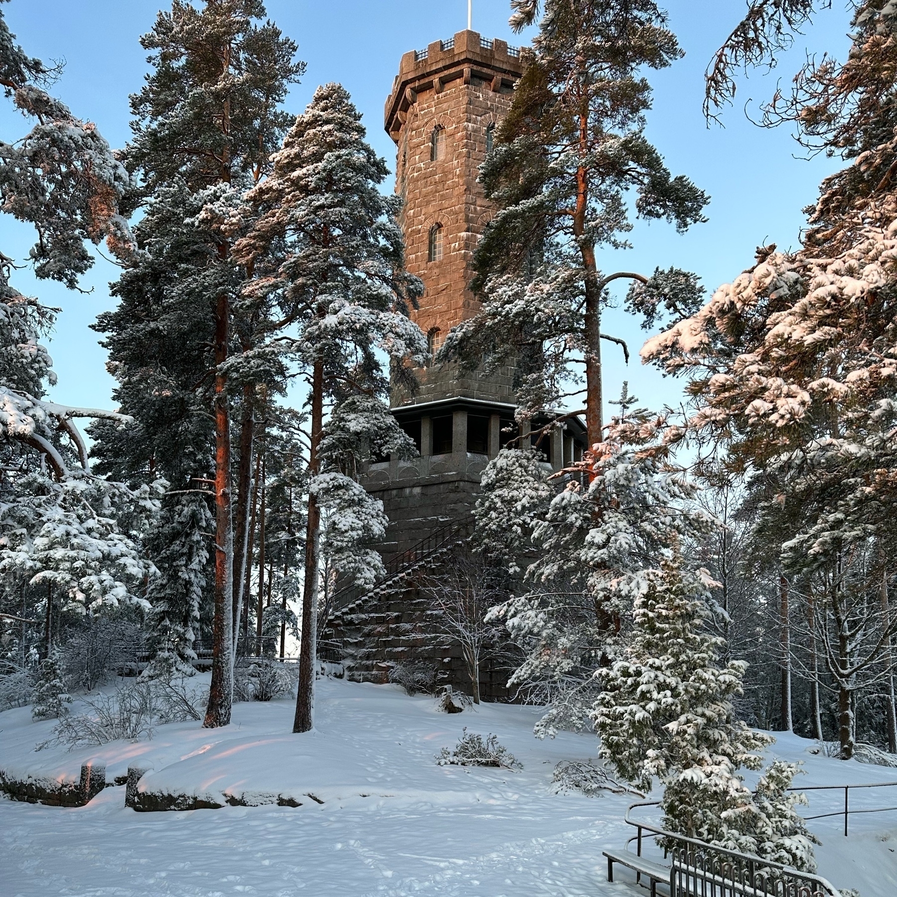 sightseeing tower built of granite, faux romantic style at Aulanko Hämeenlinna. Rising sun caressing the frozen stone edifice
