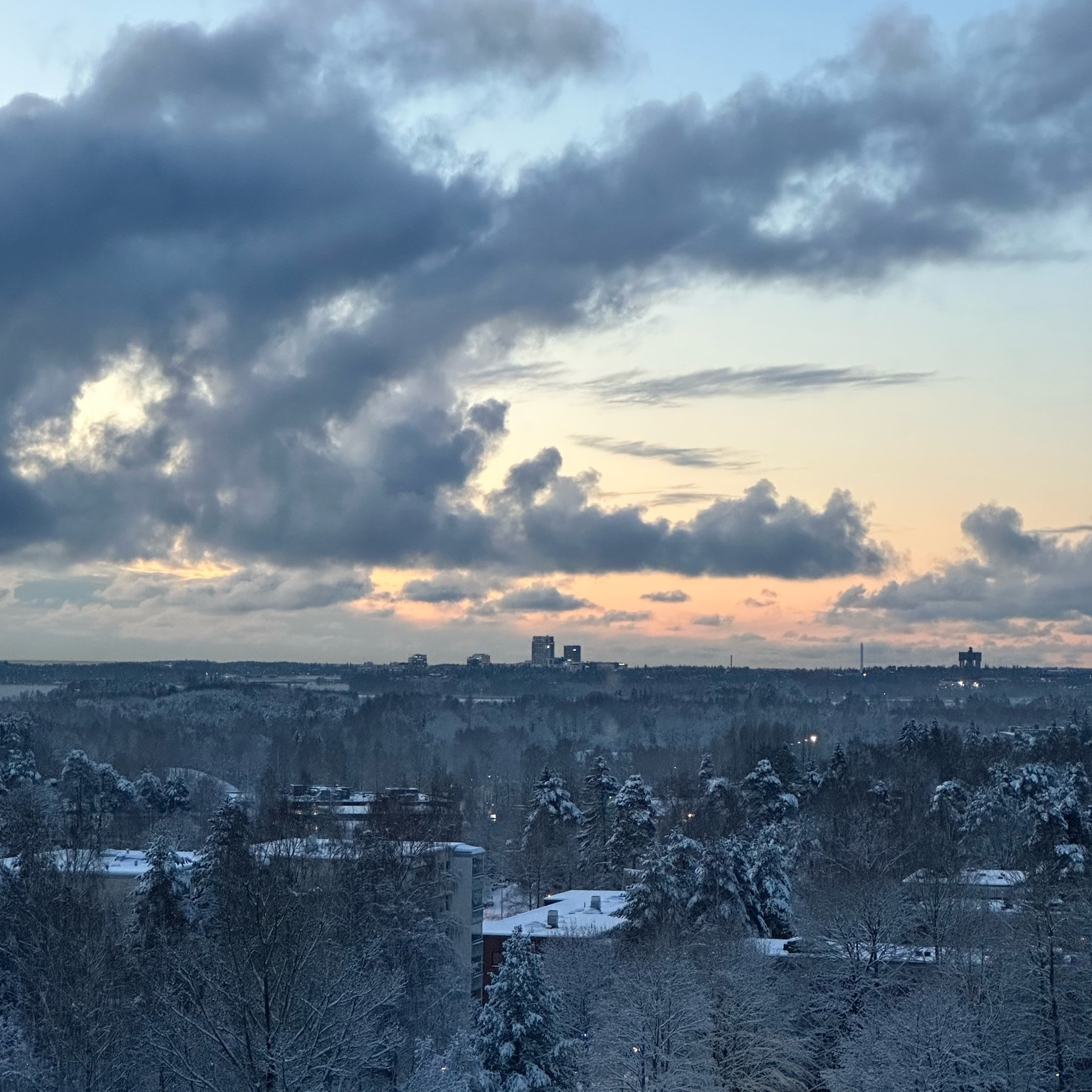view over snowy Helsinki. Clouds, snowy trees and rooftops